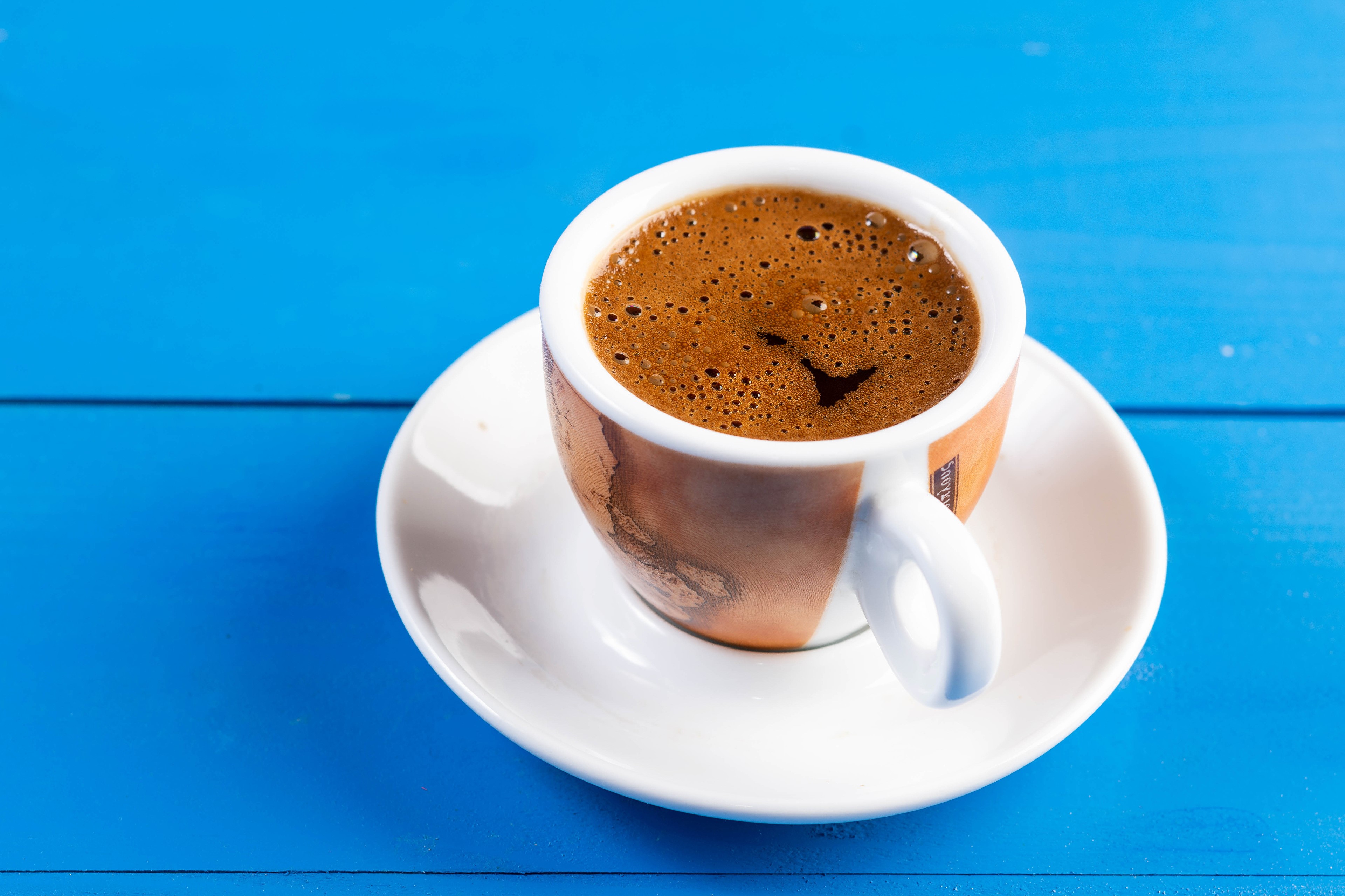 Coffee cup and saucer on blue background HD Wallpaper