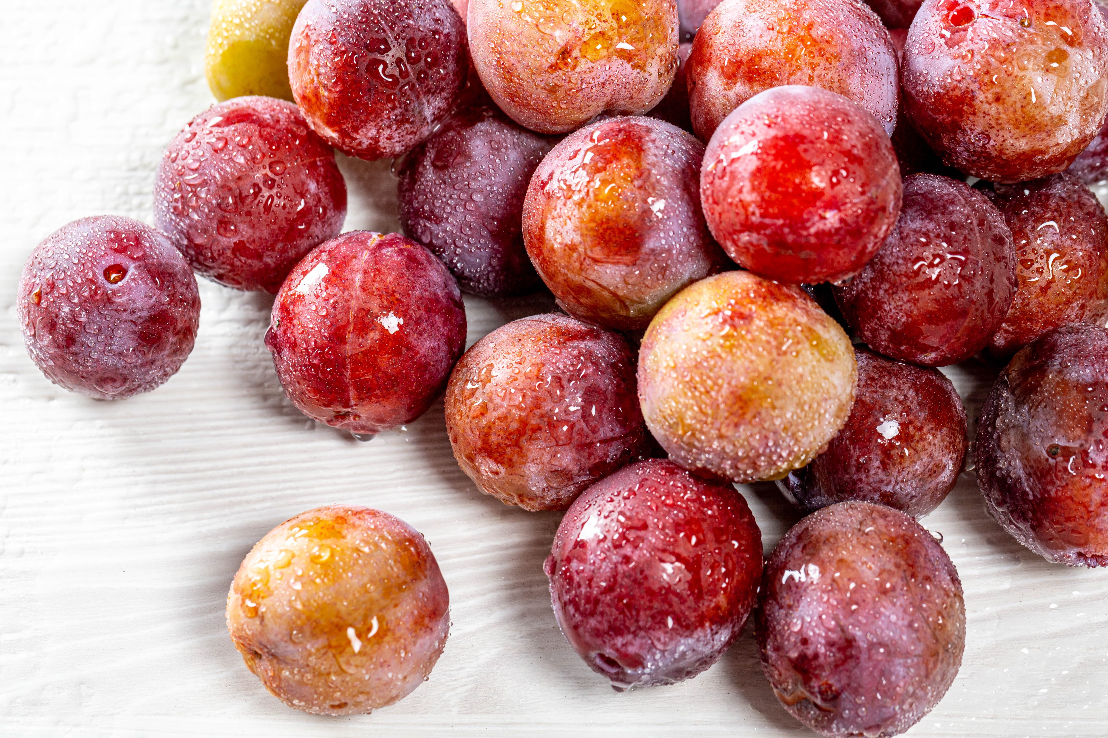 Plums with water drops on wood planks HD Wallpaper