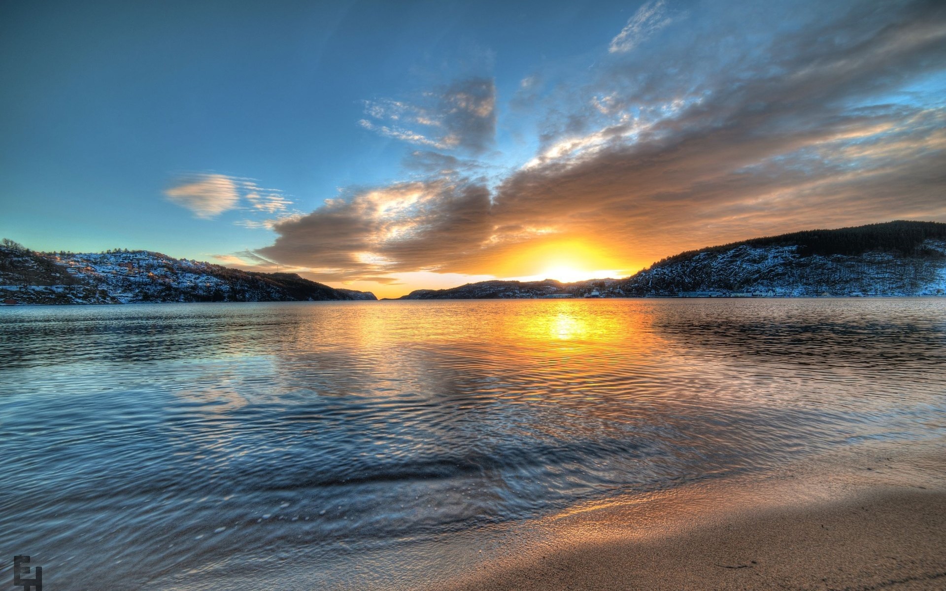 Sunset over a calm bay with snow-covered hills HD Wallpaper