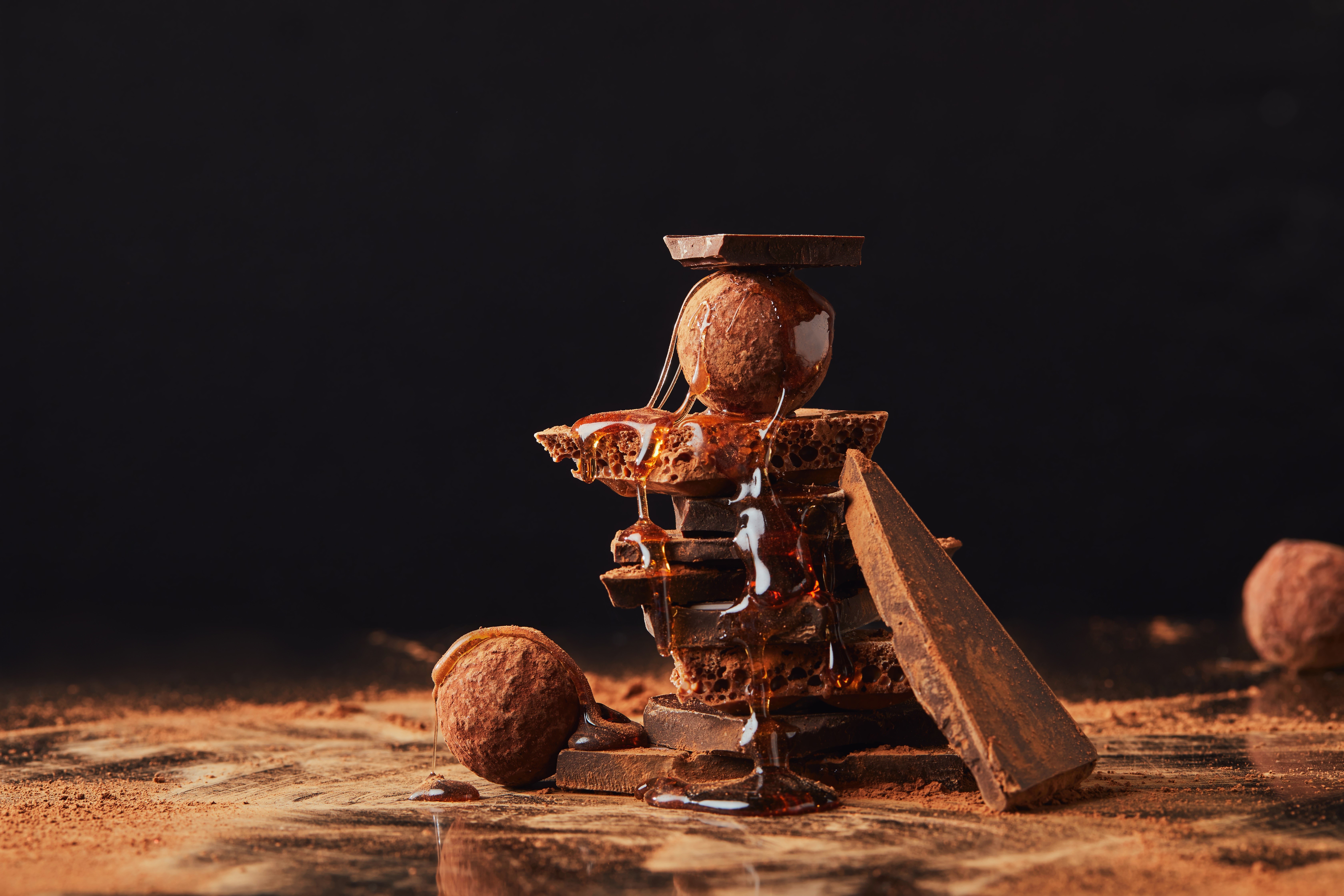 Chocolate truffles and broken chocolate bars with honey HD Wallpaper