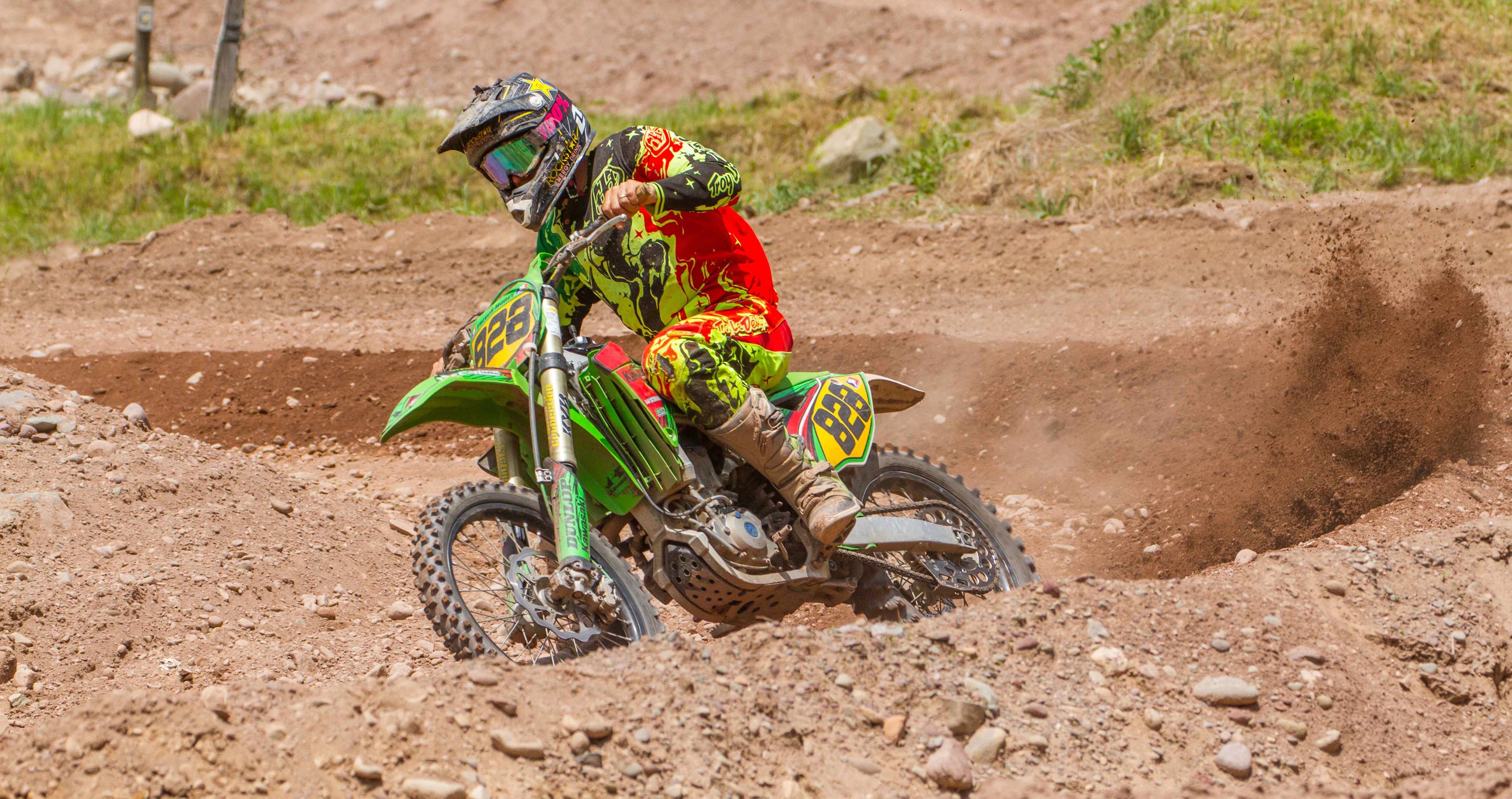 Motocross rider in action on a dirt track HD Wallpaper