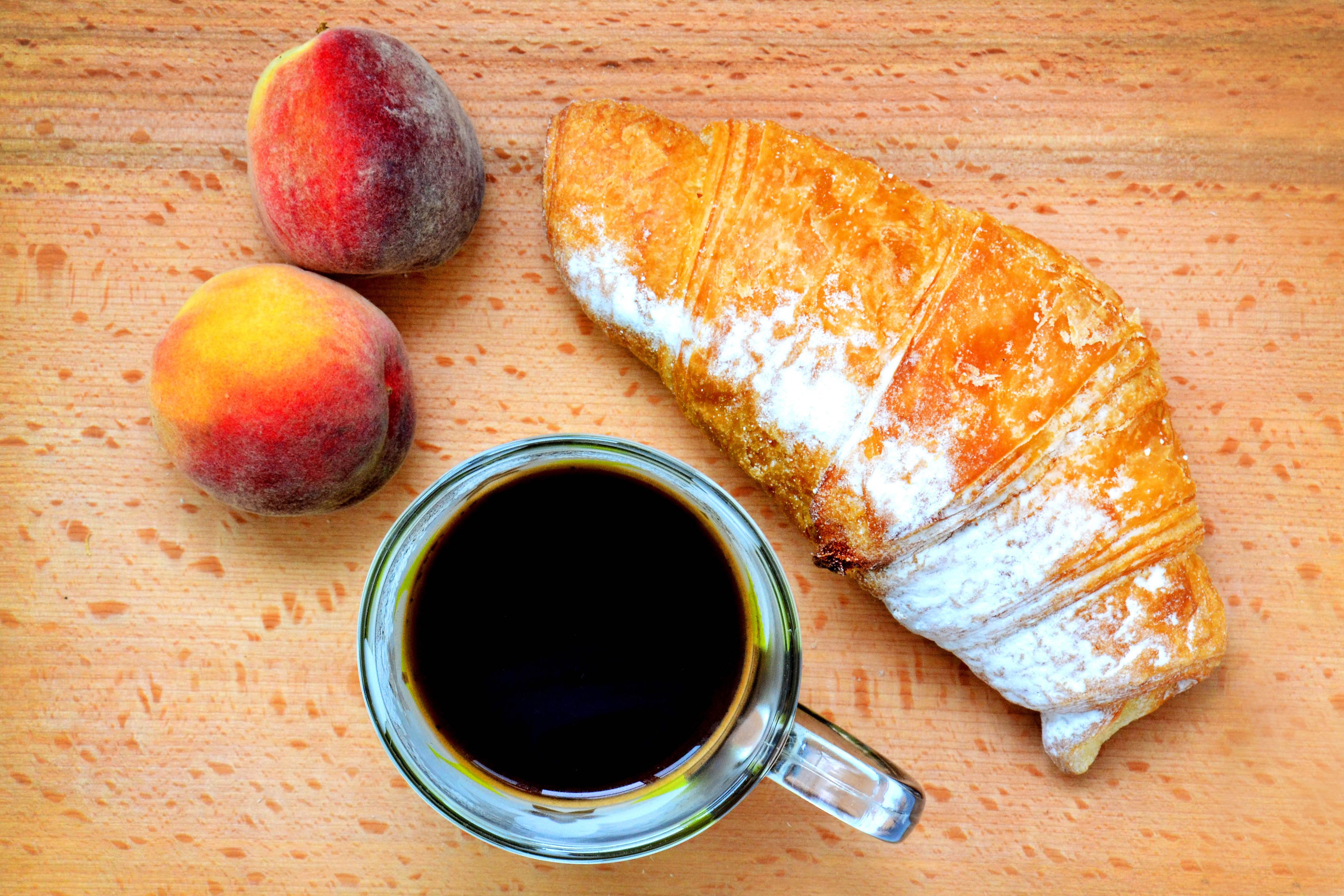 Coffee, Croissant, and Peaches on a Wooden Surface HD Wallpaper