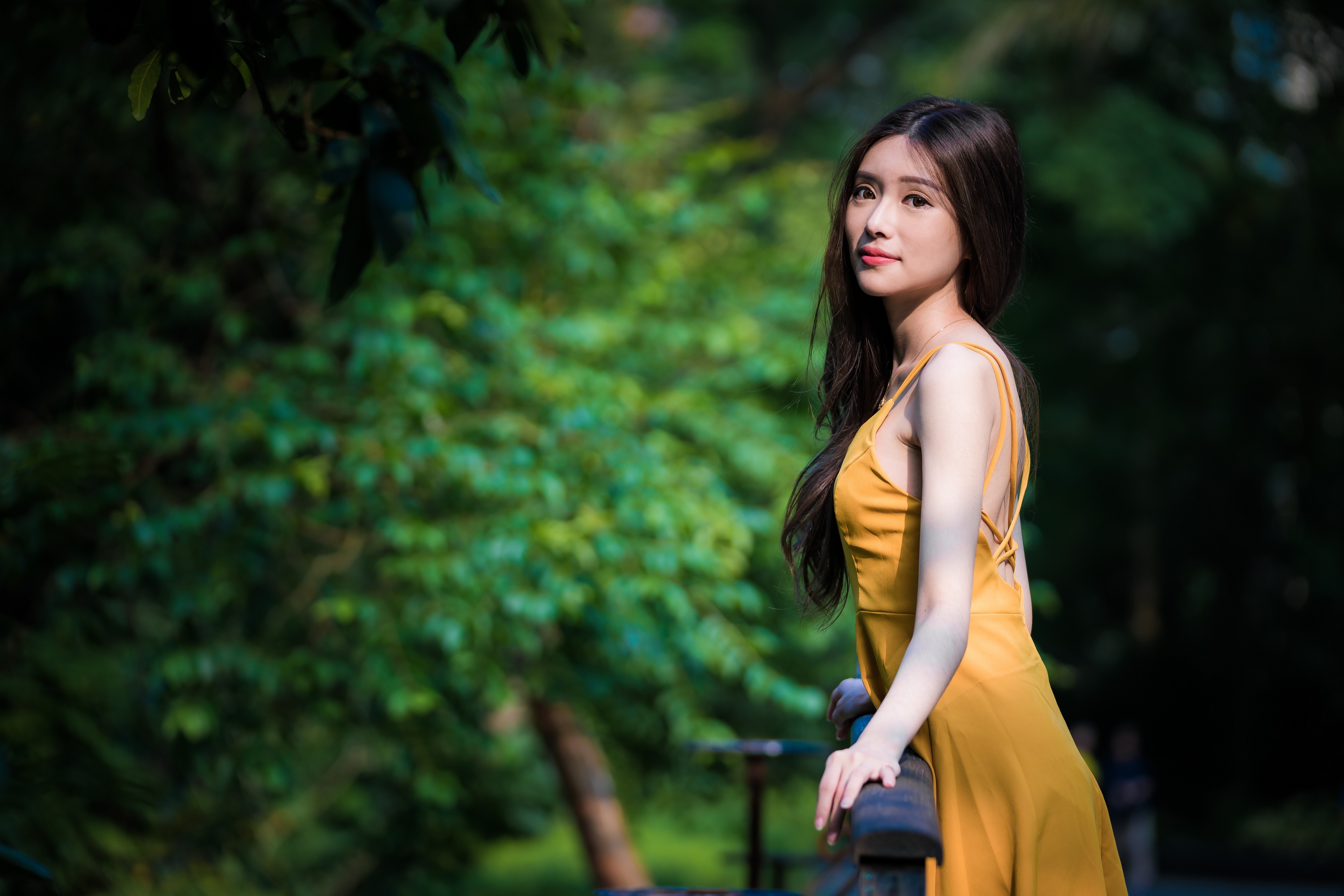 Brunette girl in yellow dress in a park HD Wallpaper
