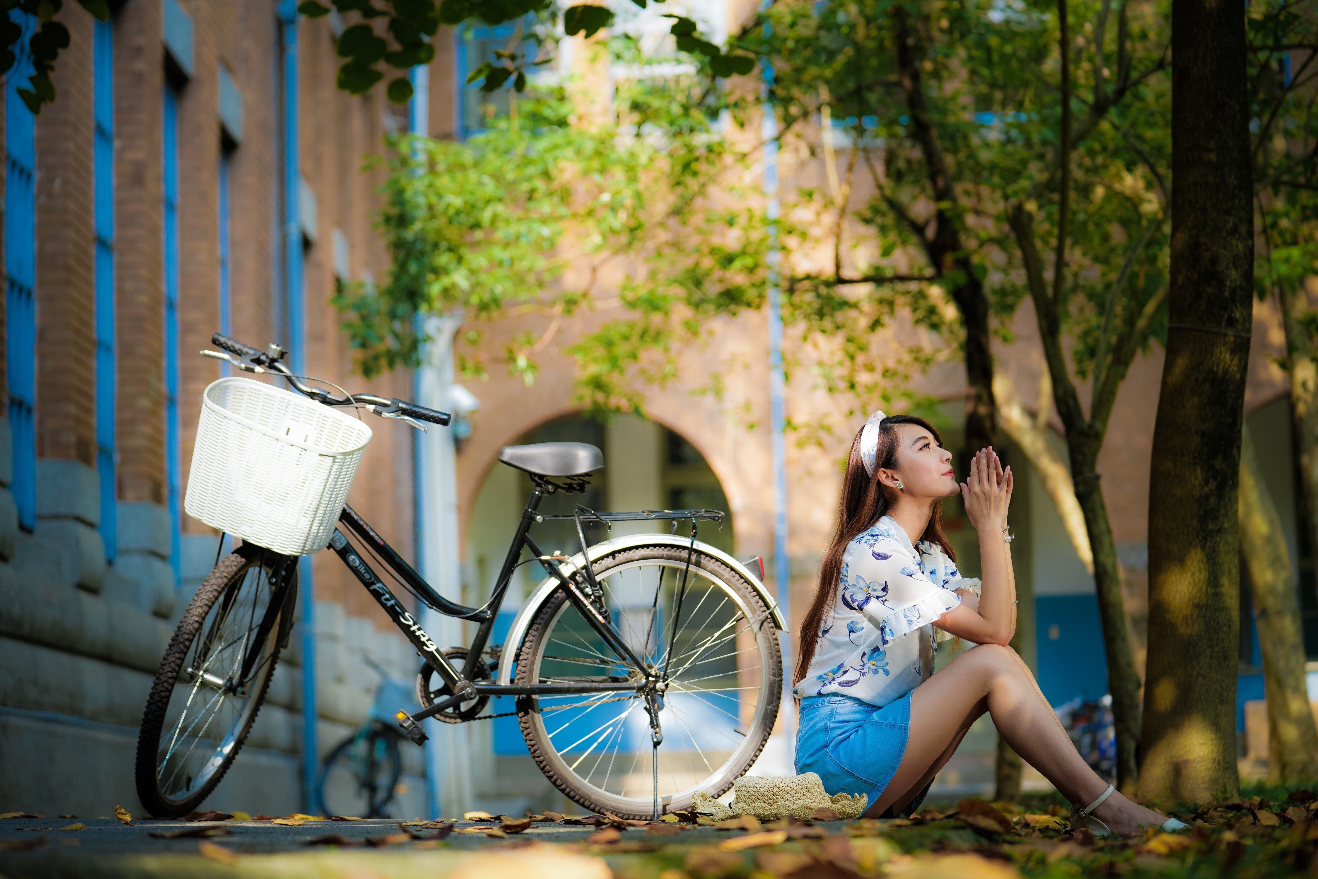 Asian woman sitting by a bicycle with a wicker basket HD Wallpaper