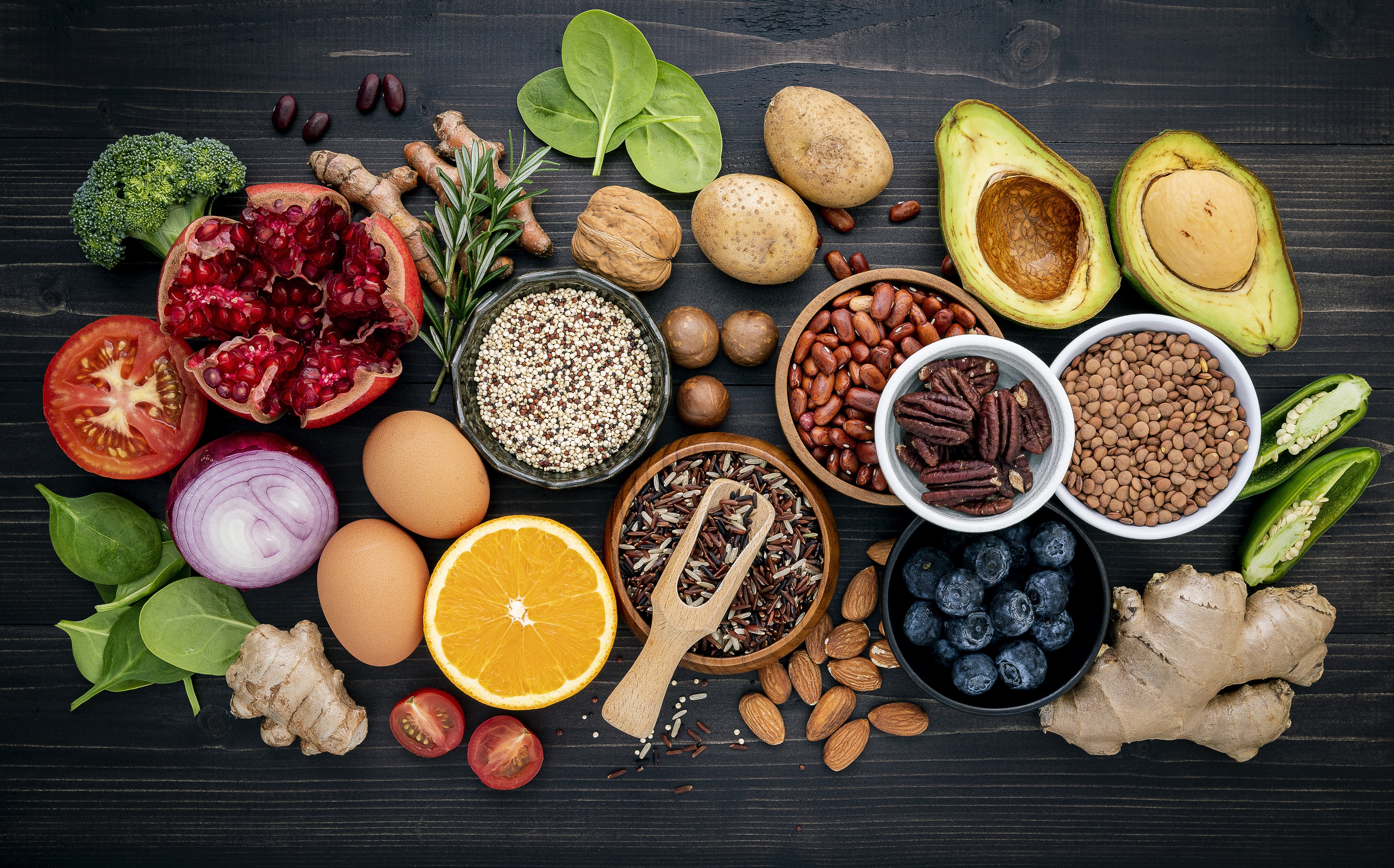 Assortment of Healthy Foods: Pomegranate, Avocado, Eggs, Nuts, and Grains HD Wallpaper