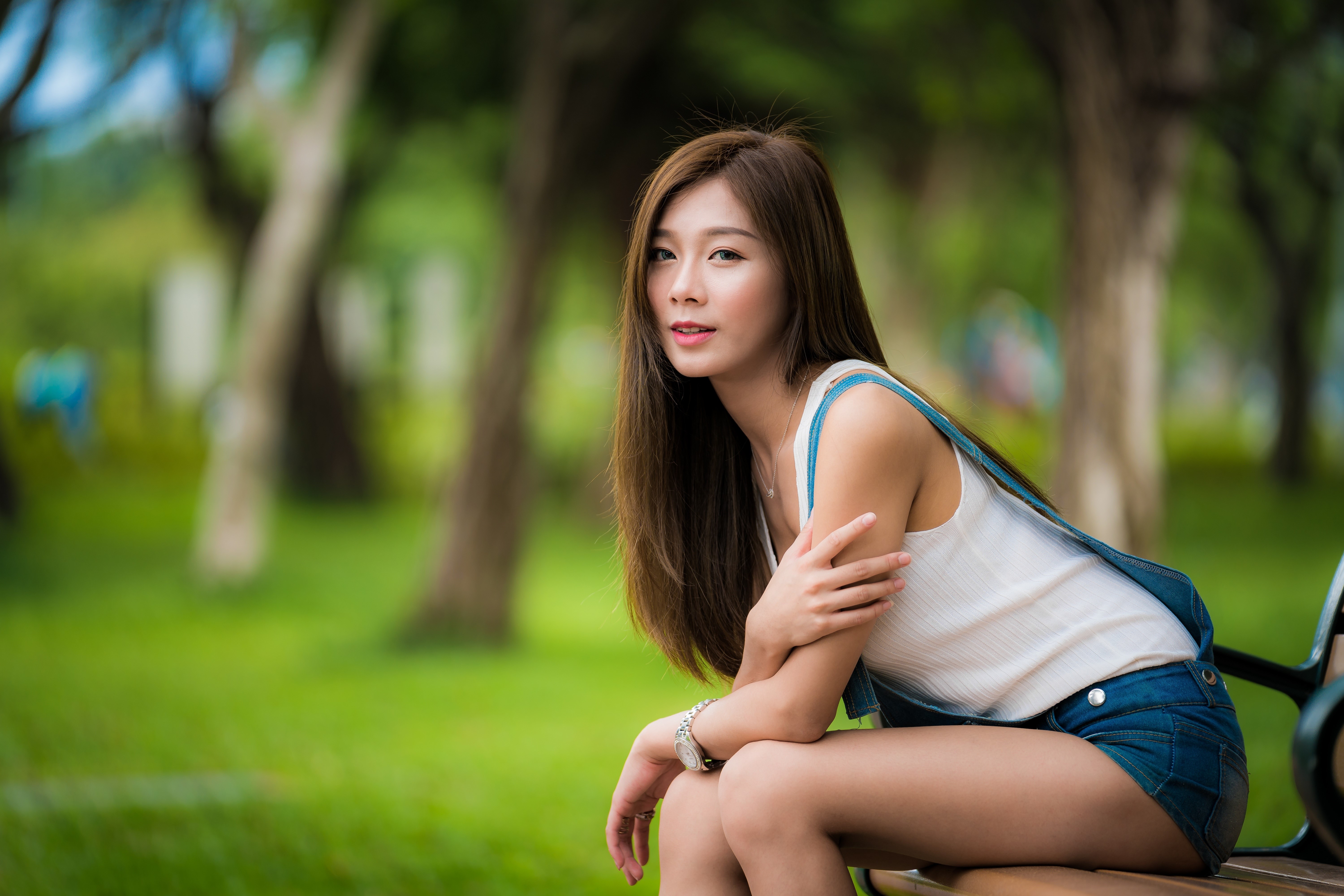 Woman sitting on a bench in a park HD Wallpaper