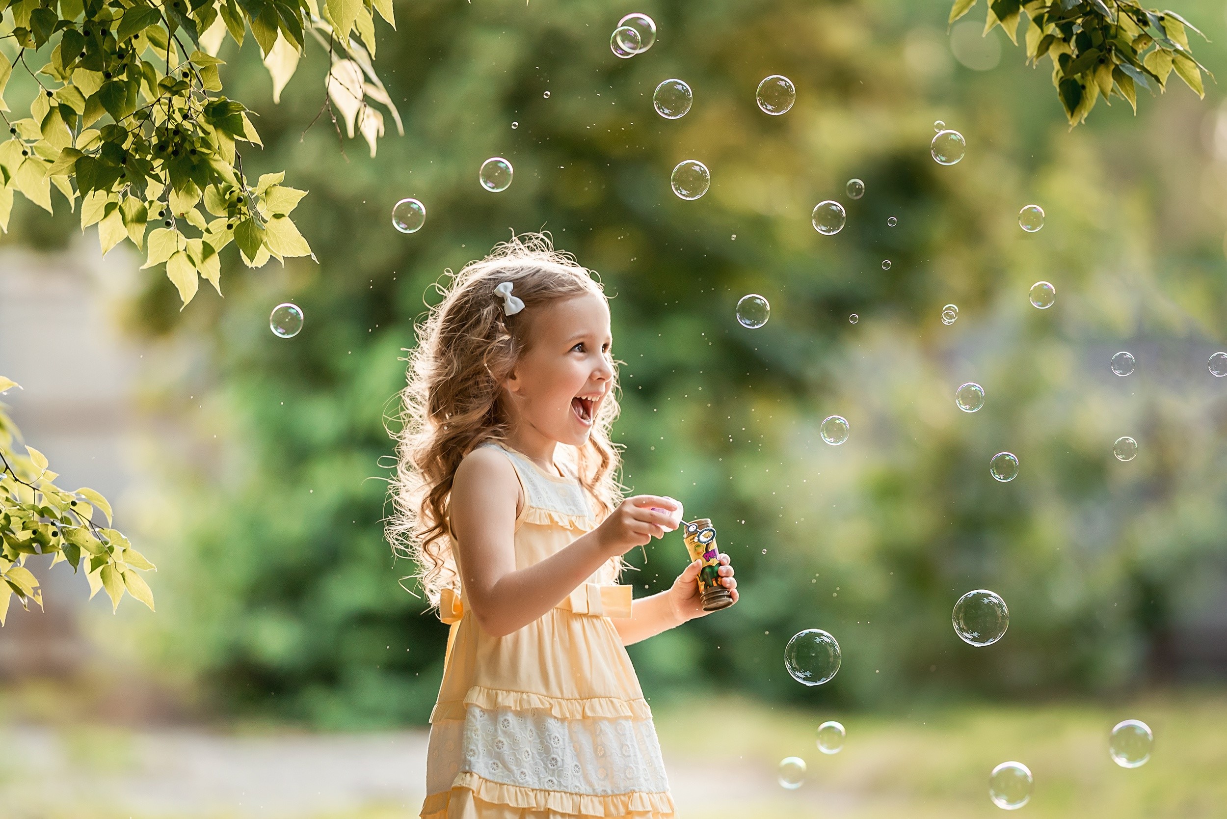 Little girl blowing soap bubbles HD Wallpaper