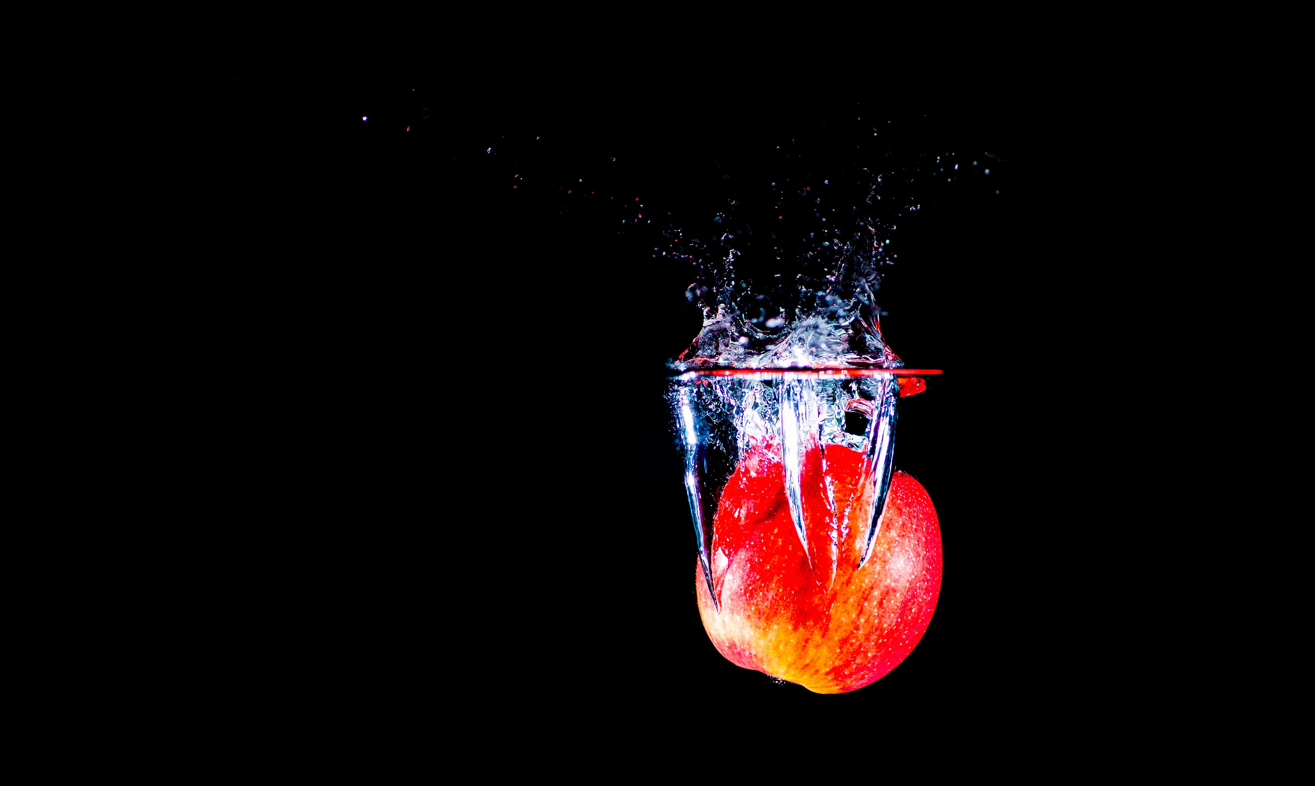 Red apple splashing into water HD Wallpaper