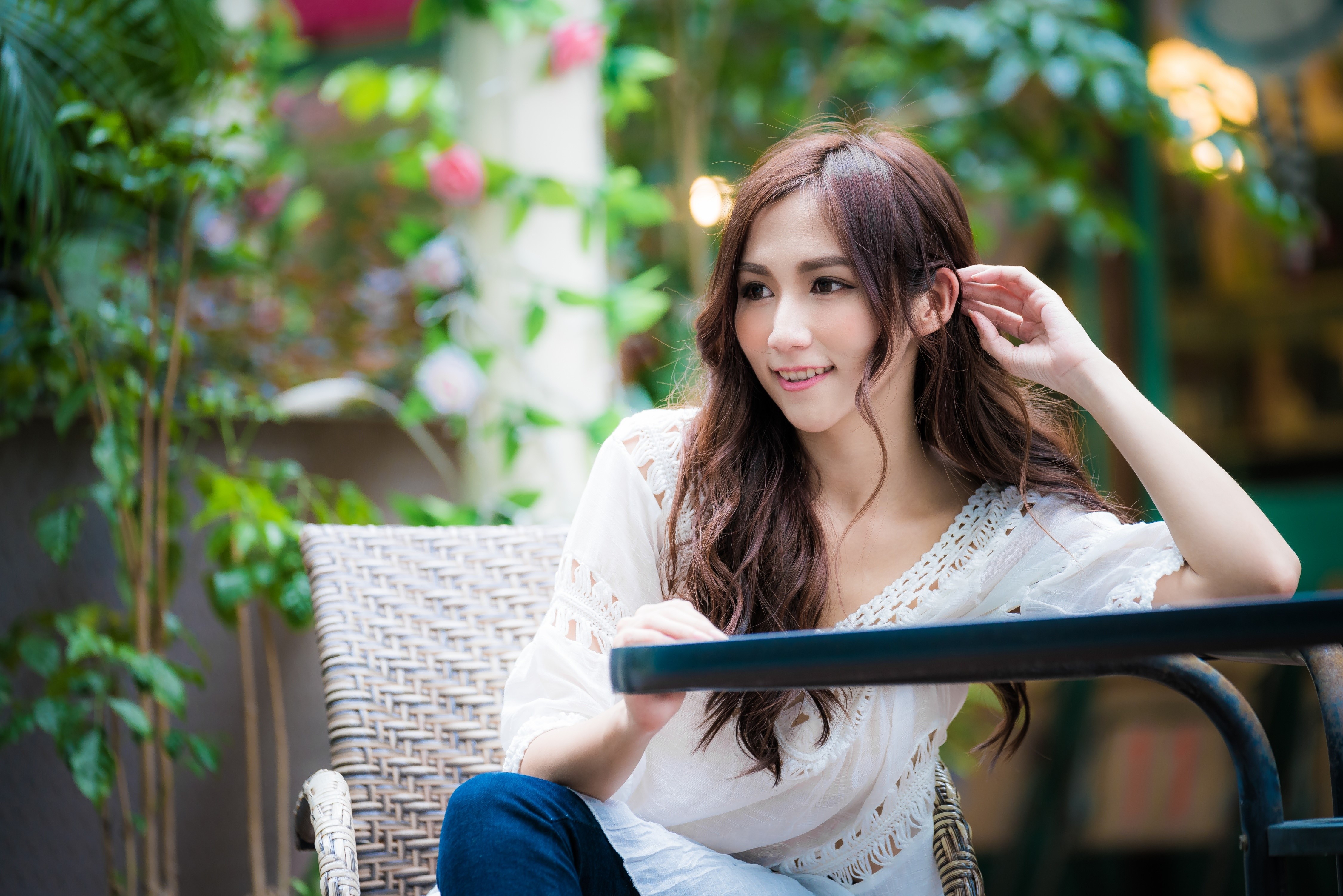 Asian woman with brown hair sitting at a table HD Wallpaper