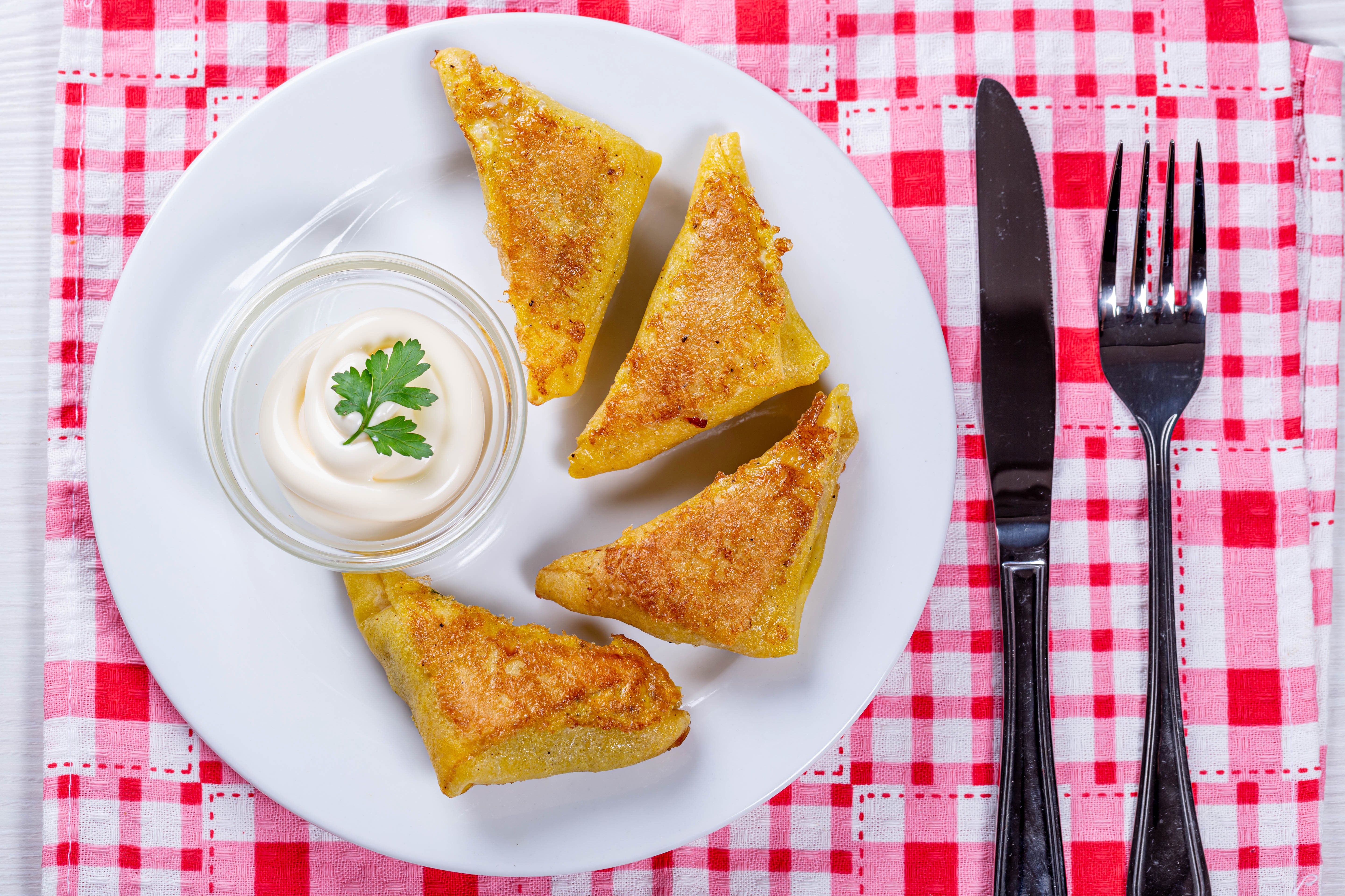 Fried triangular sandwiches with sour cream on a plate HD Wallpaper