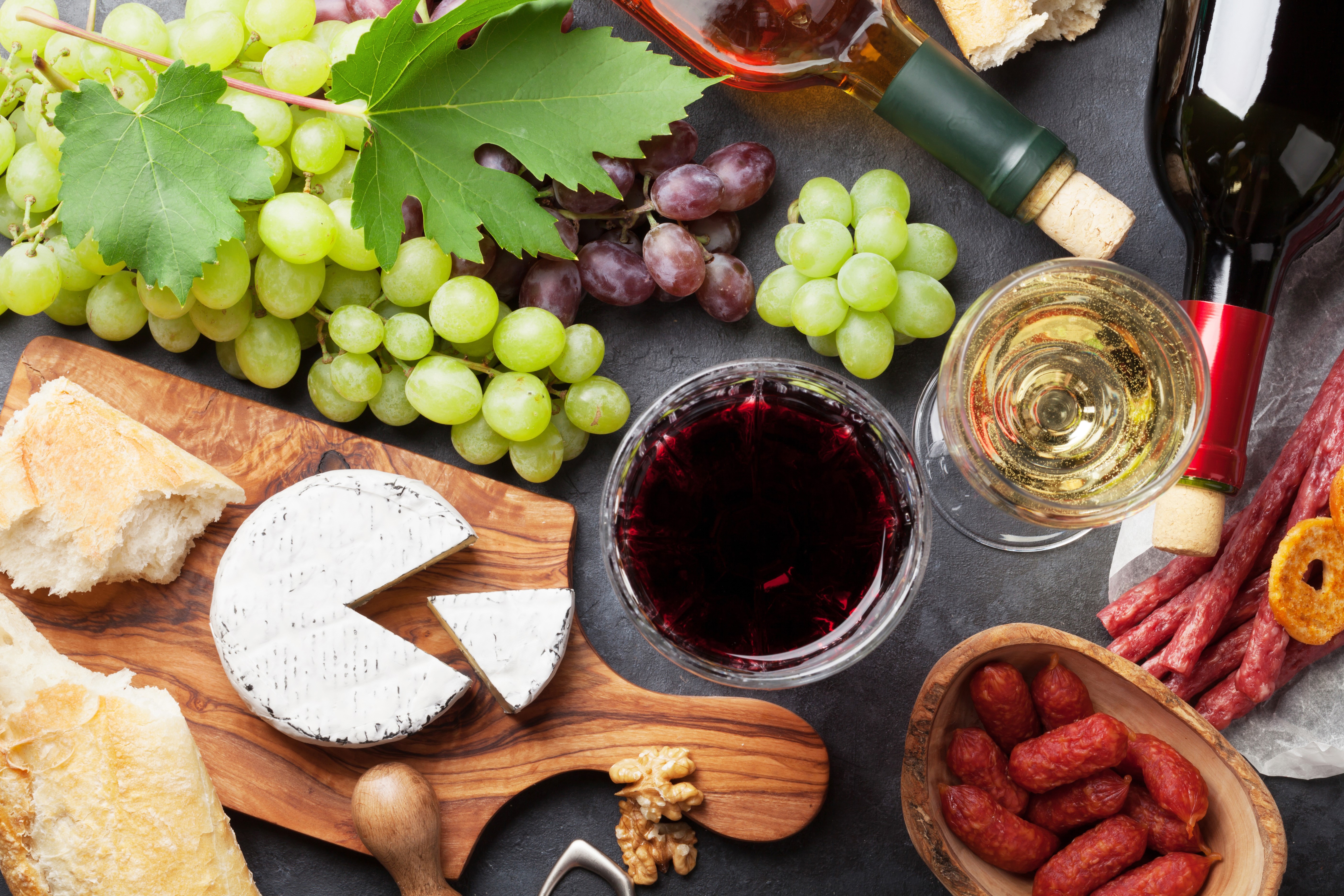 Wine, Grapes, Cheese, Sausage, and Bread on a Cutting Board HD Wallpaper