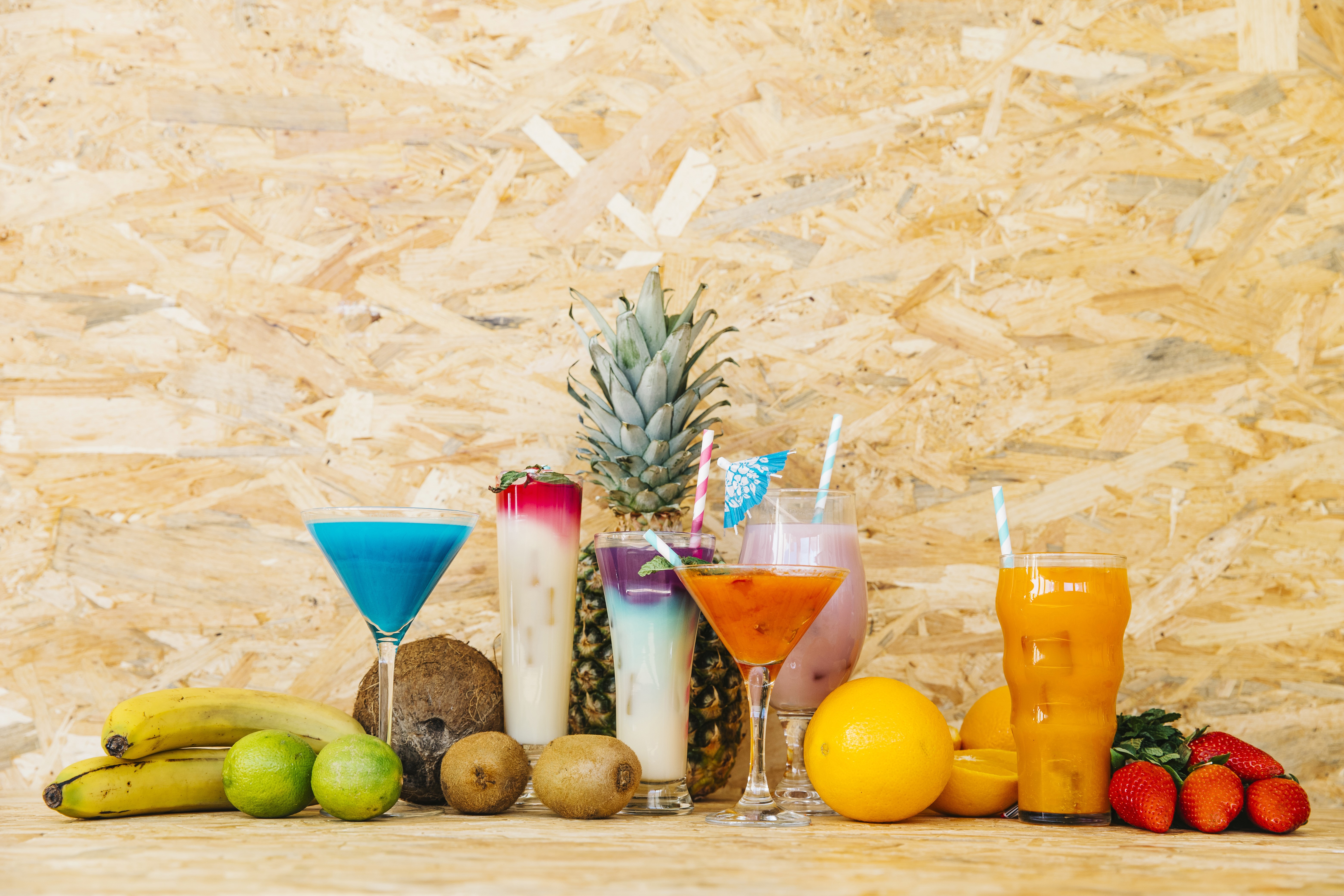 Assortment of tropical fruits and colorful cocktails HD Wallpaper