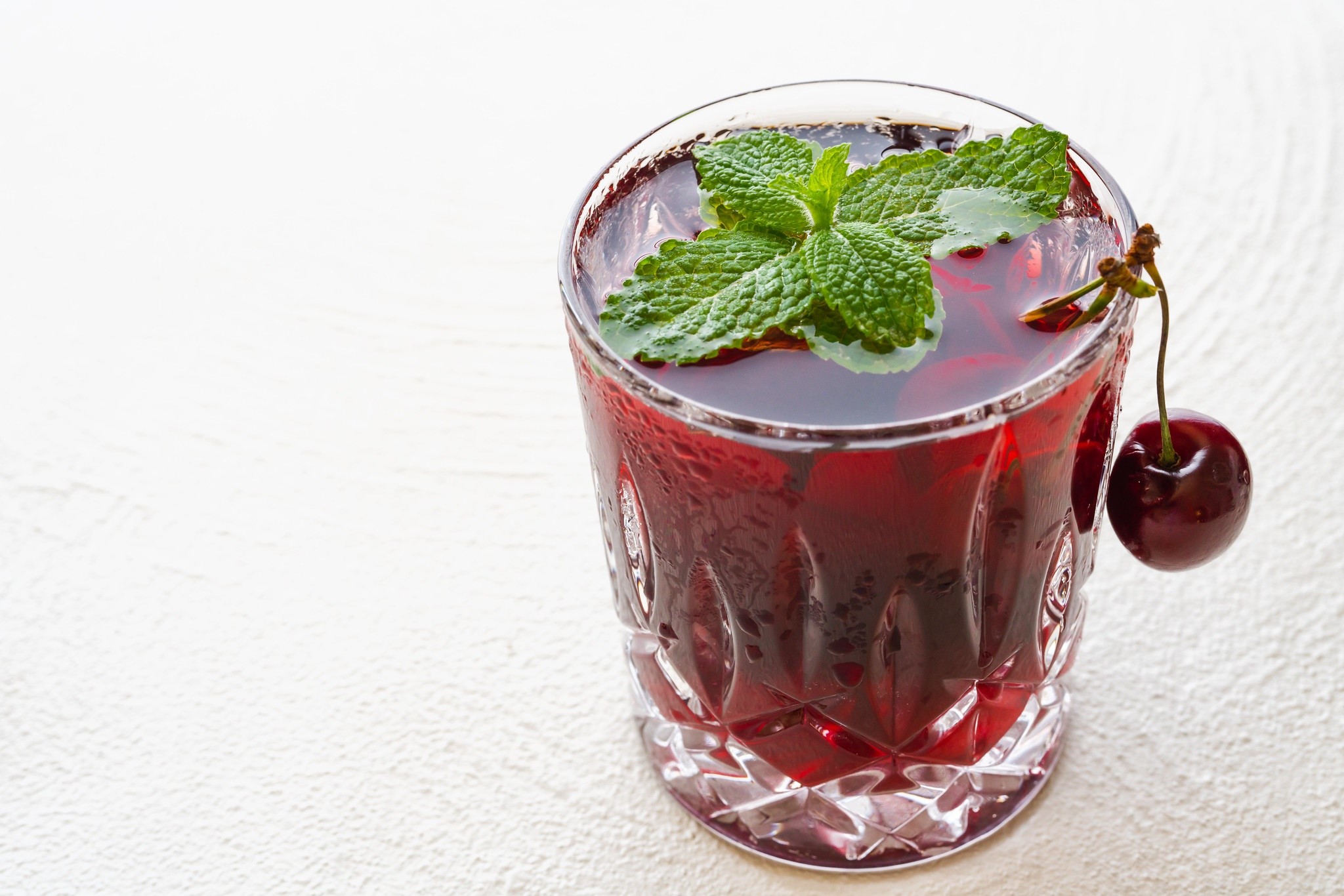 Cherry juice with mint and cherry garnish in a glass HD Wallpaper