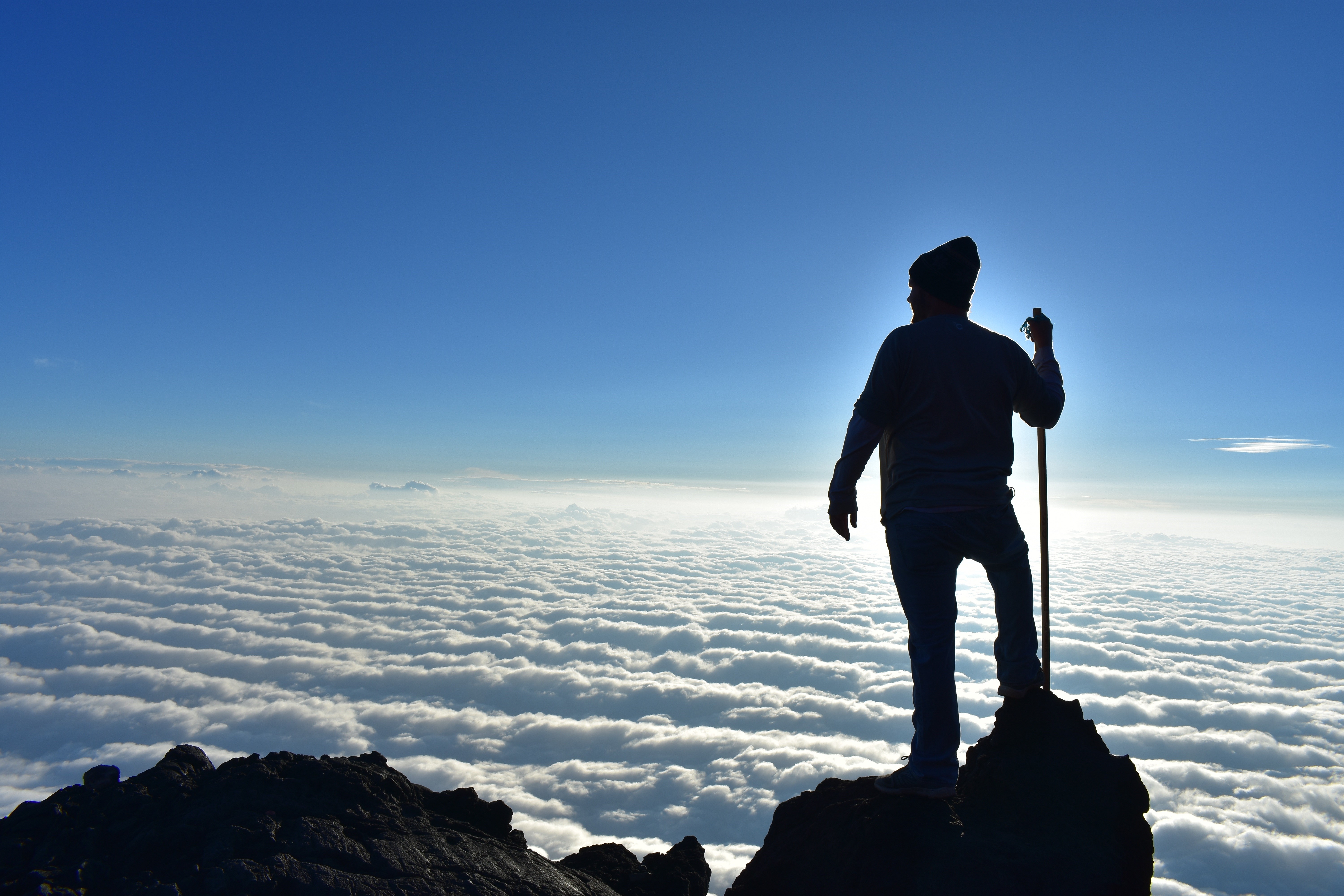 Climber on a mountaintop above clouds HD Wallpaper