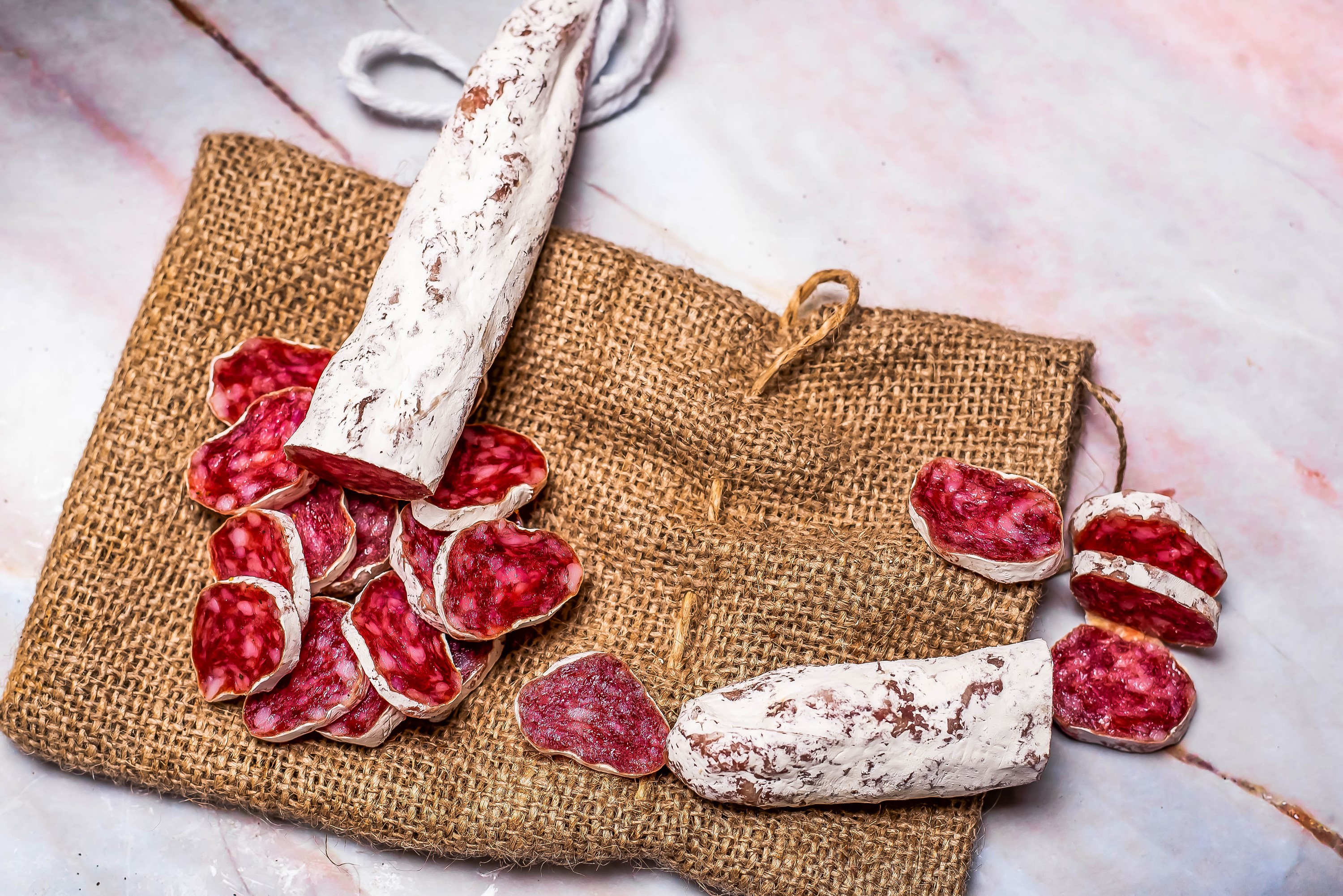 Sliced salami on burlap HD Wallpaper