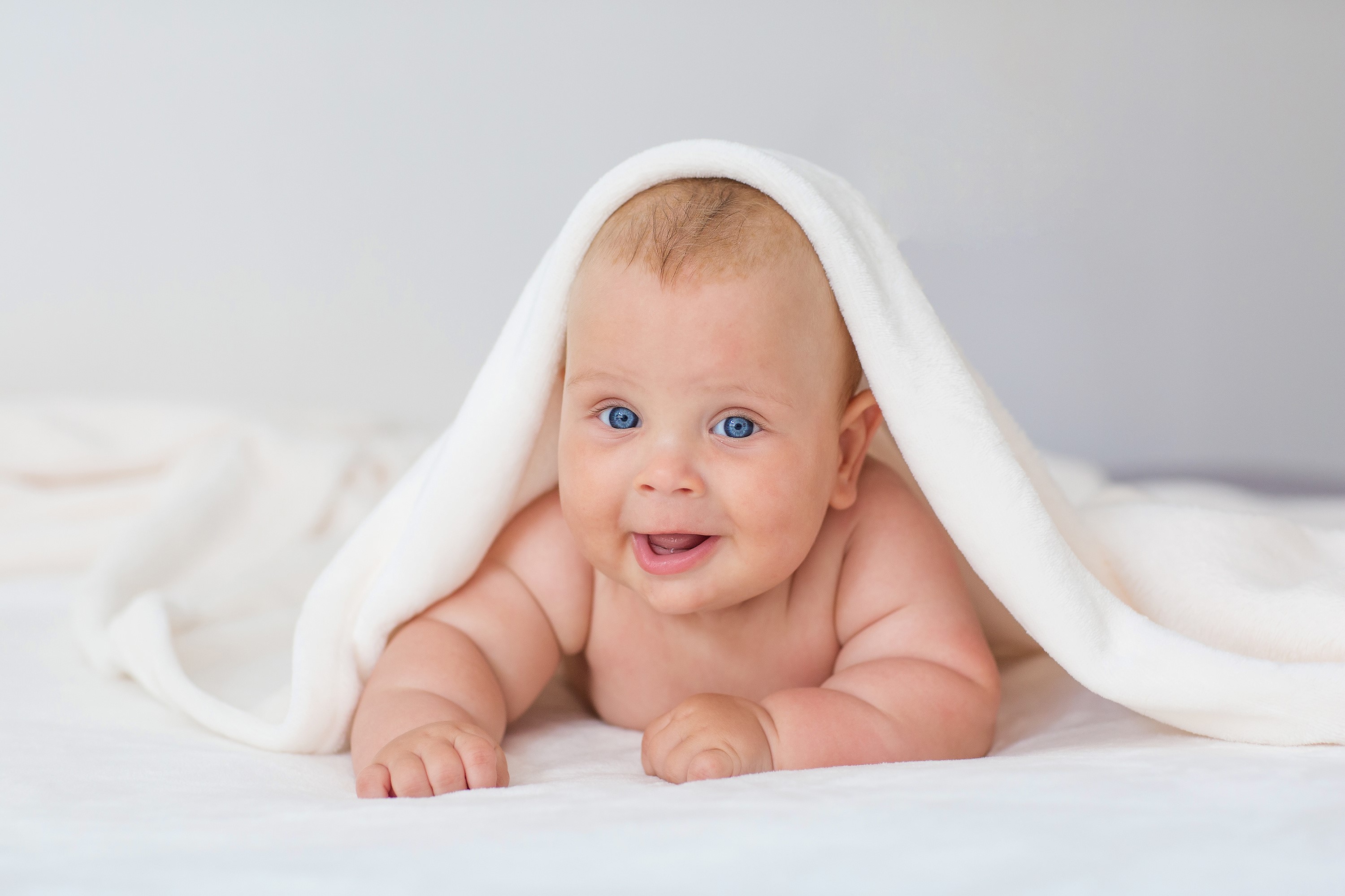 Baby with blue eyes under a towel HD Wallpaper