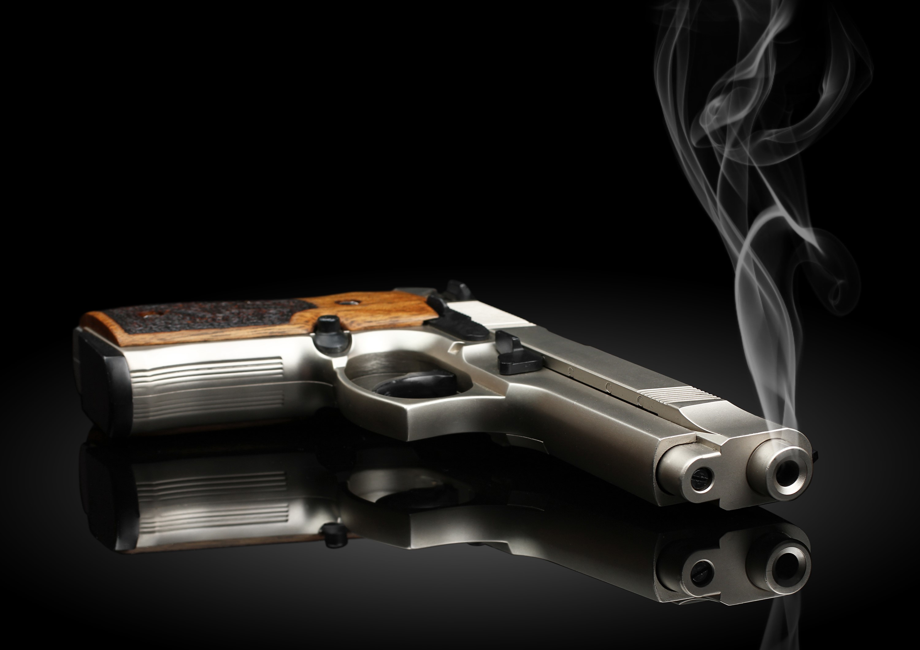 Pistol with smoke on a black background HD Wallpaper