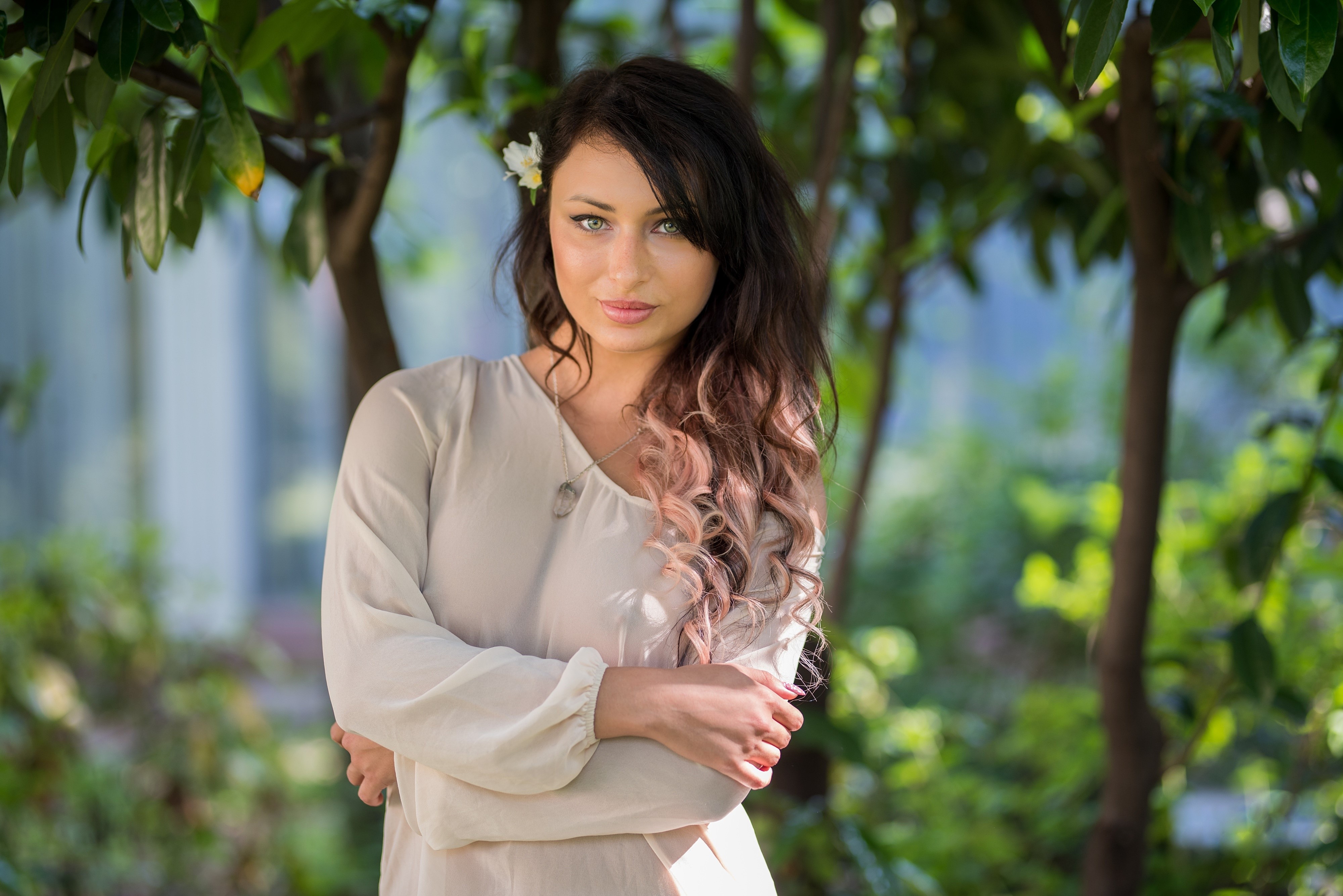 Brunette girl with flower in hair and crossed arms HD Wallpaper