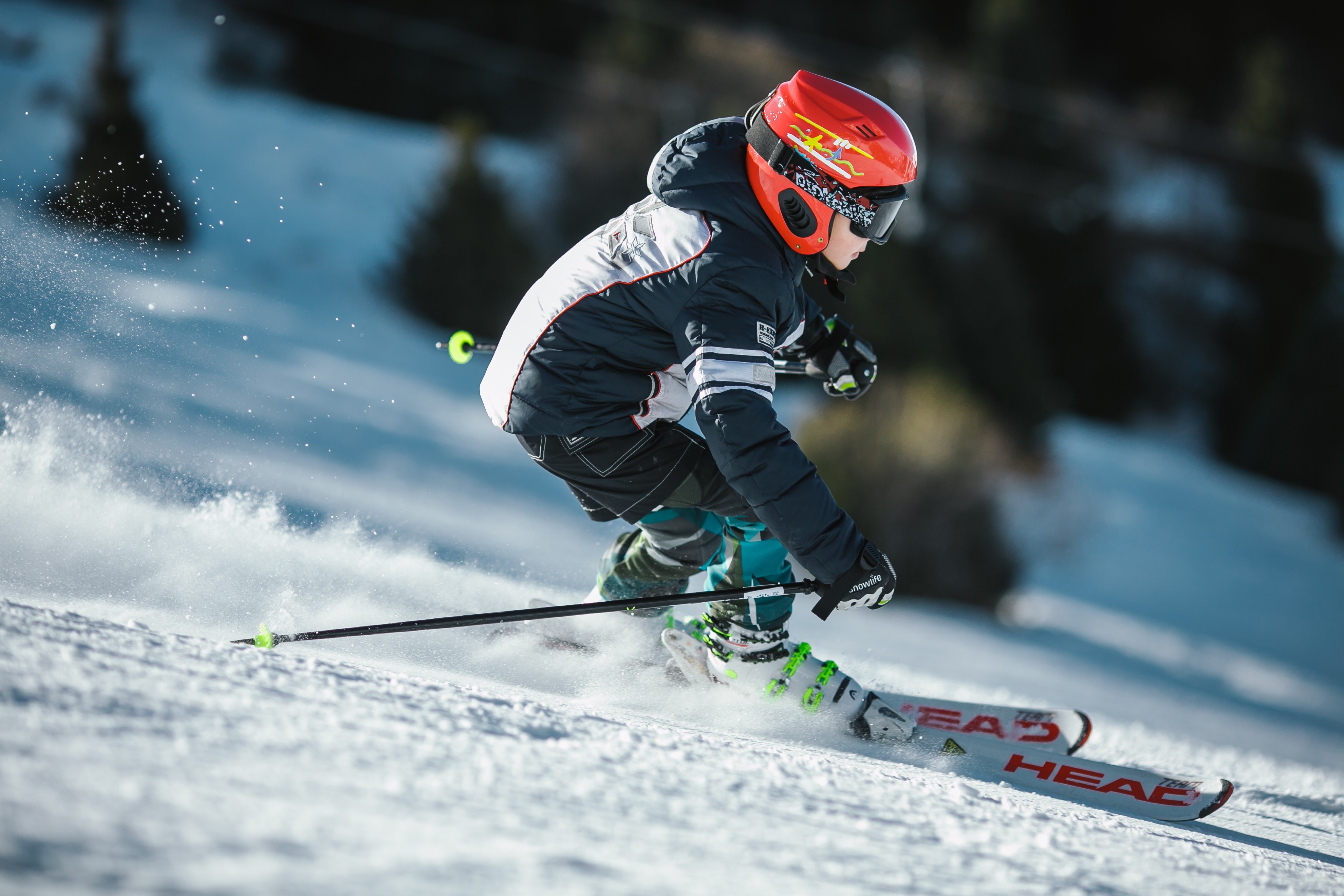 Boy skiing down a snowy slope HD Wallpaper