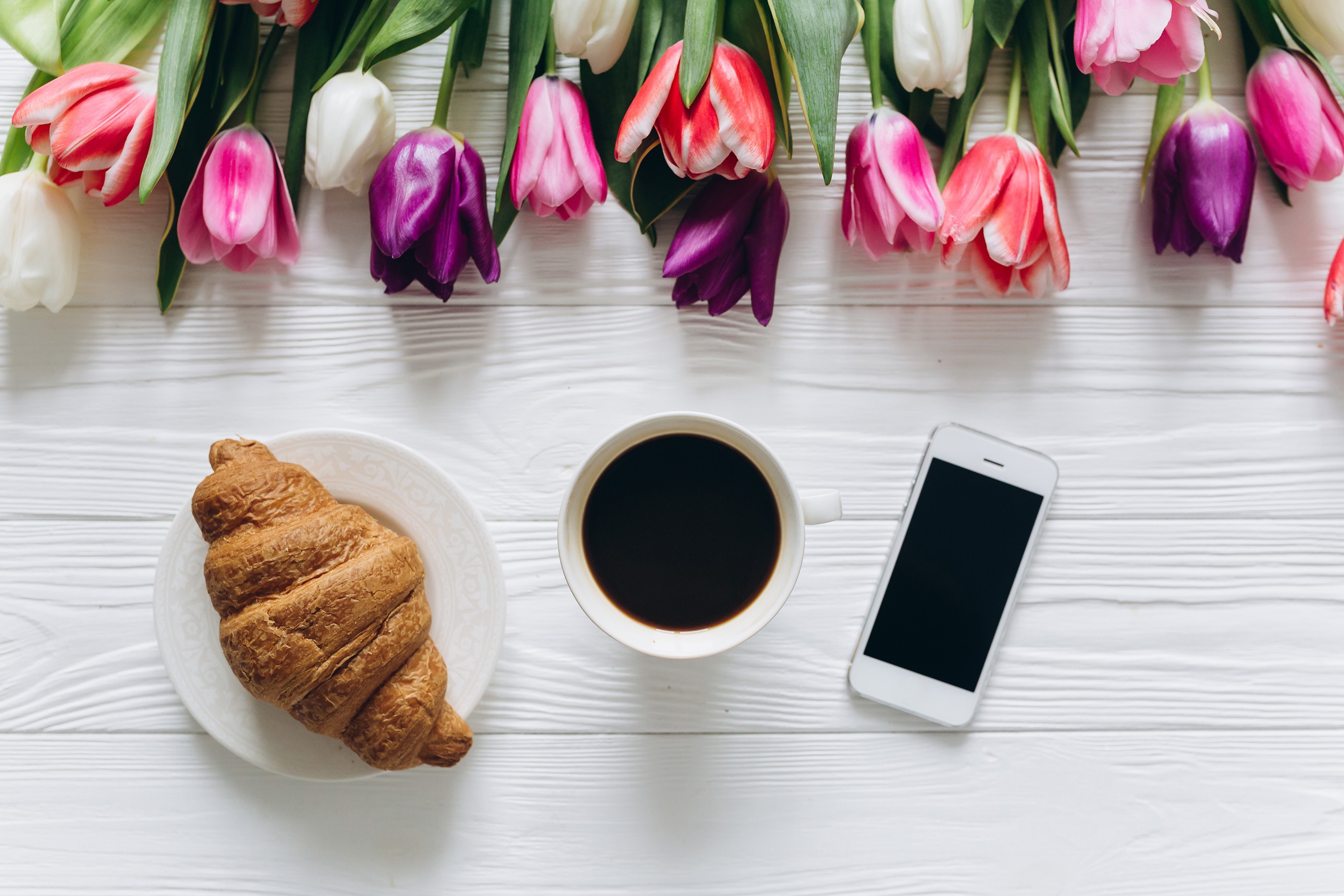 Coffee, Croissant, Tulips, and Smartphone on White Table HD Wallpaper