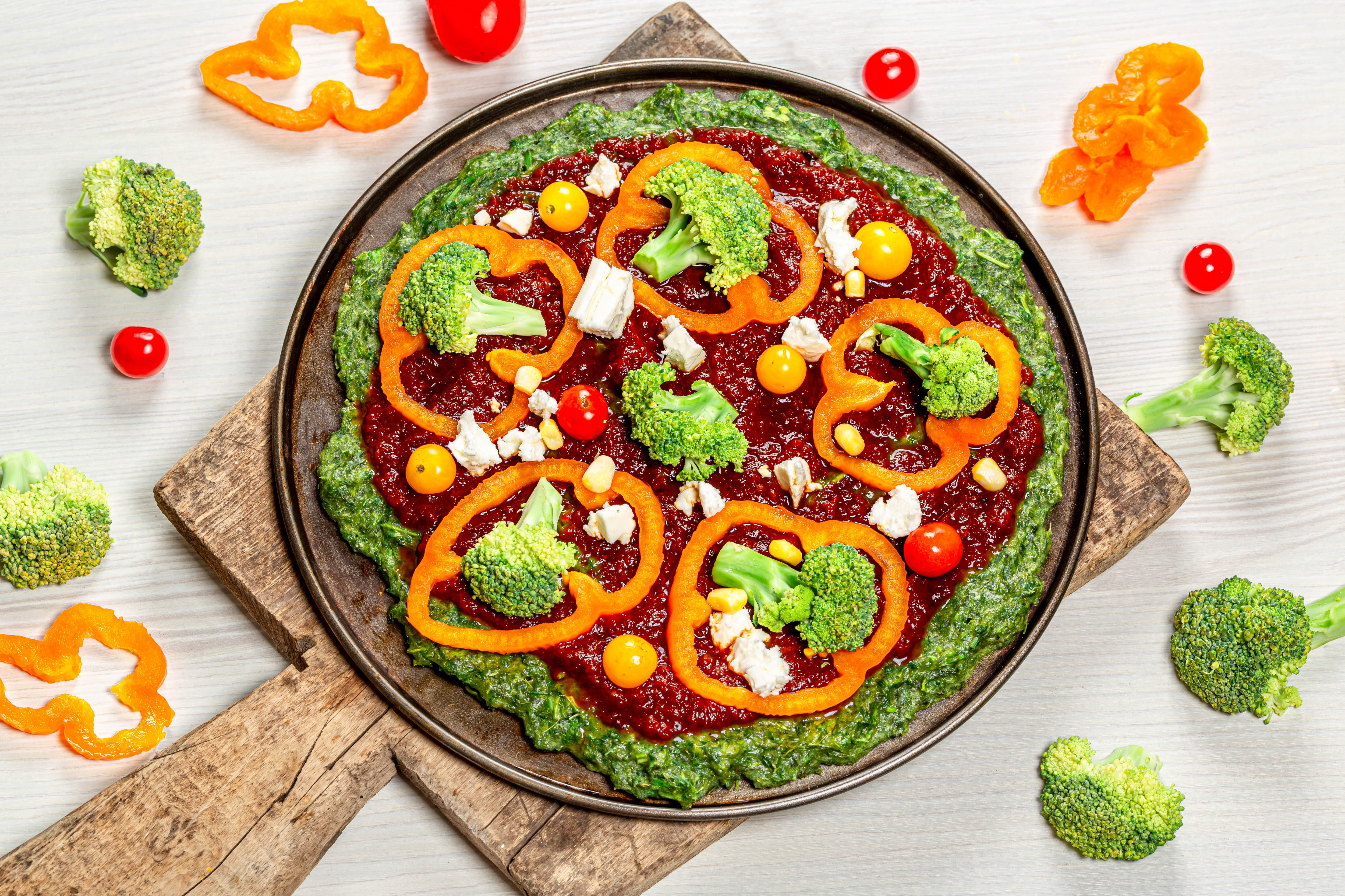 Vegetable pizza with broccoli and bell pepper on cutting board HD Wallpaper