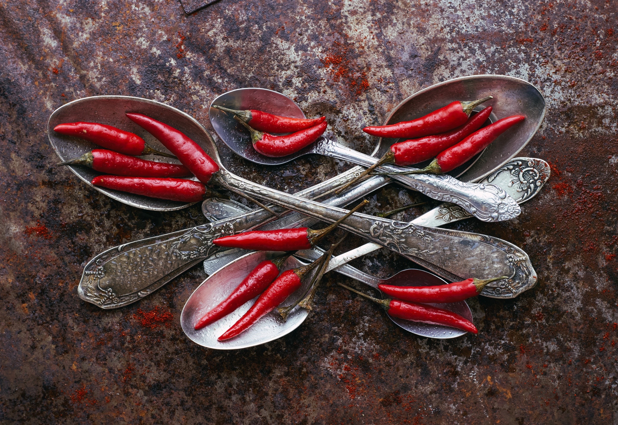 Red chili peppers in antique spoons on a rustic surface HD Wallpaper