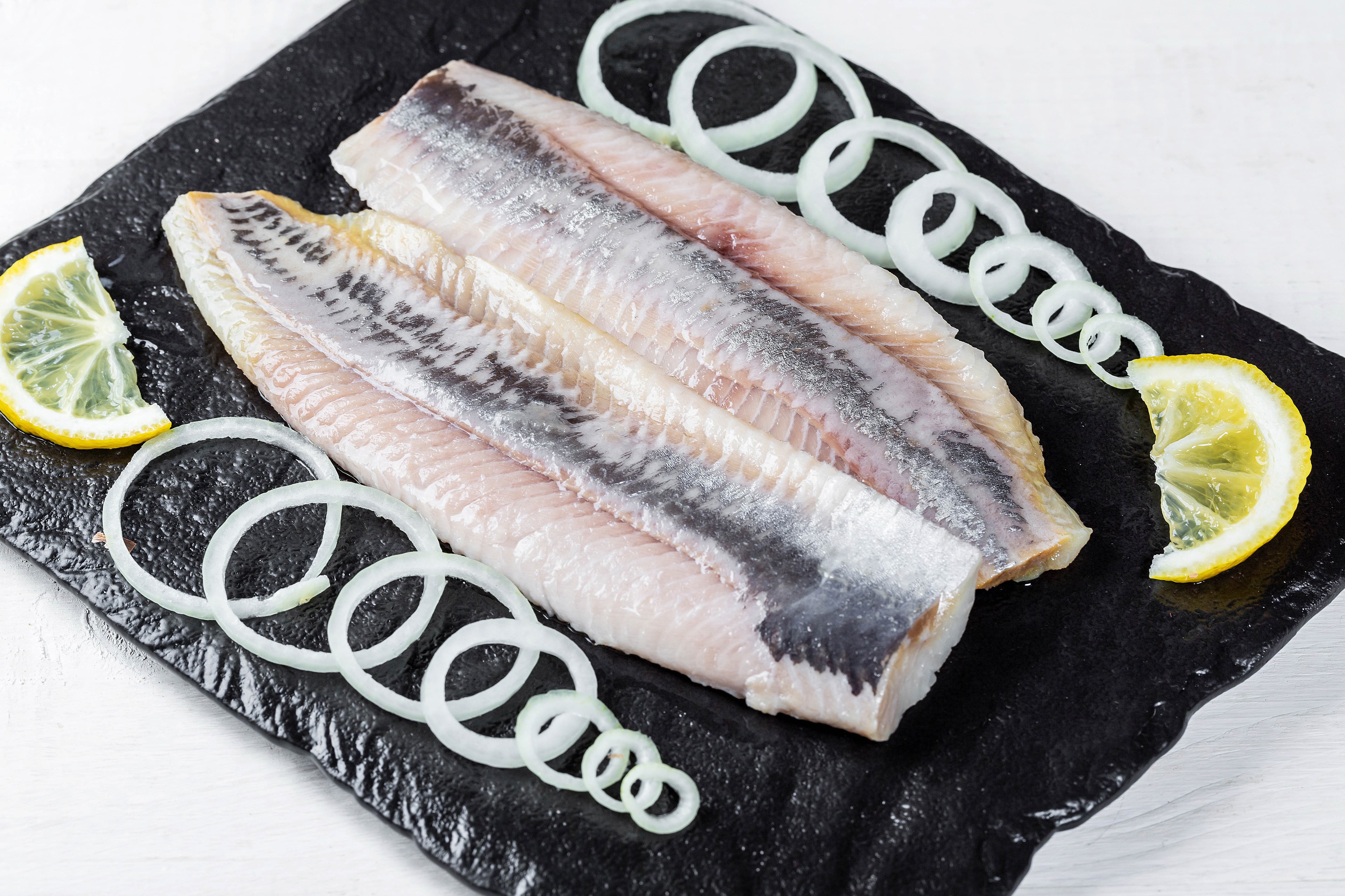 Raw herring fillets with lemon and onion rings HD Wallpaper