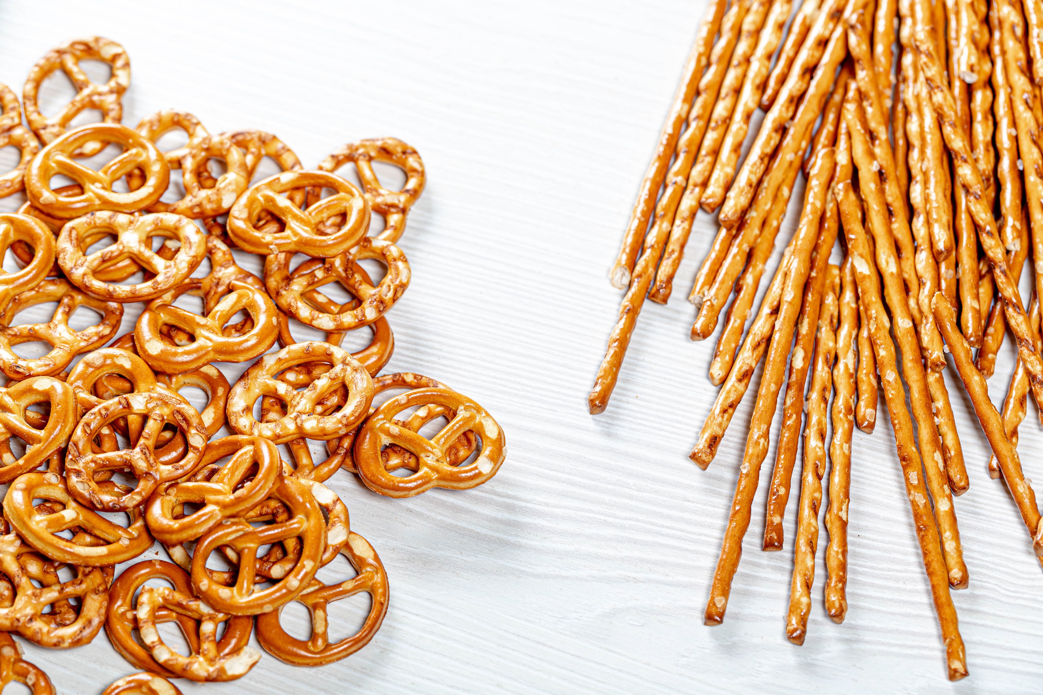 Pretzels and salty sticks on a white surface HD Wallpaper