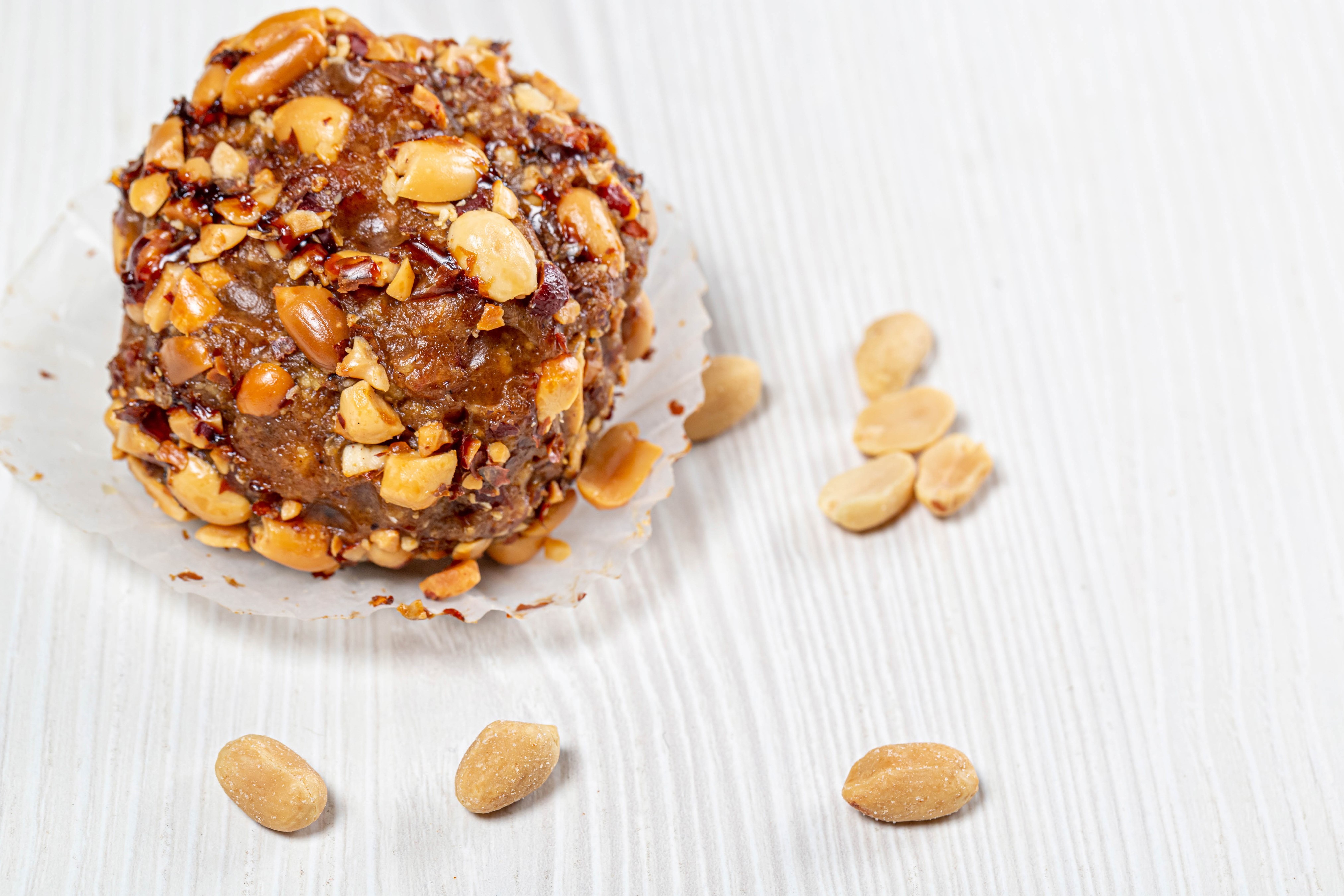 Peanut-covered dessert with scattered peanuts HD Wallpaper