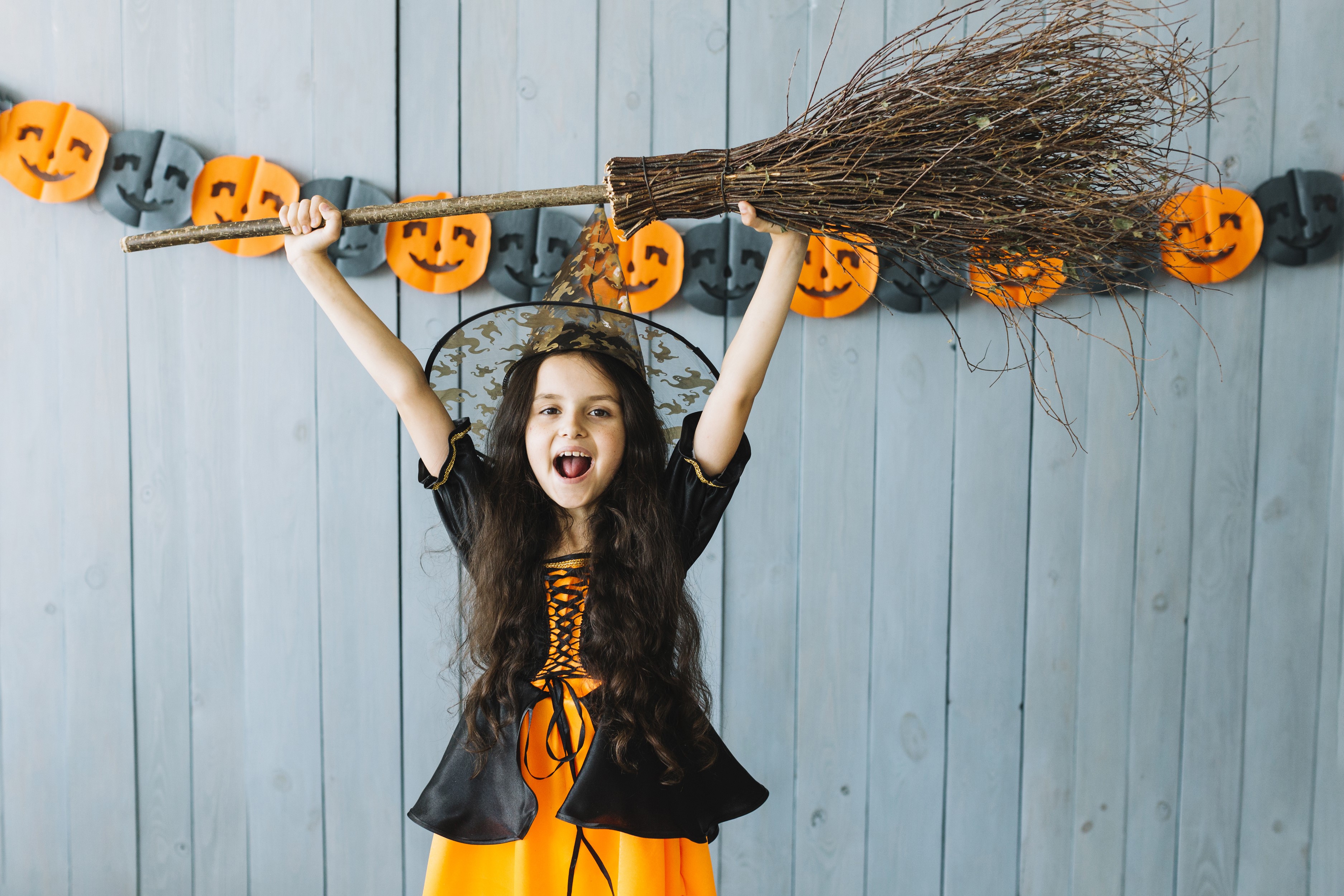 Girl in Witch Costume Holding a Broomstick HD Wallpaper