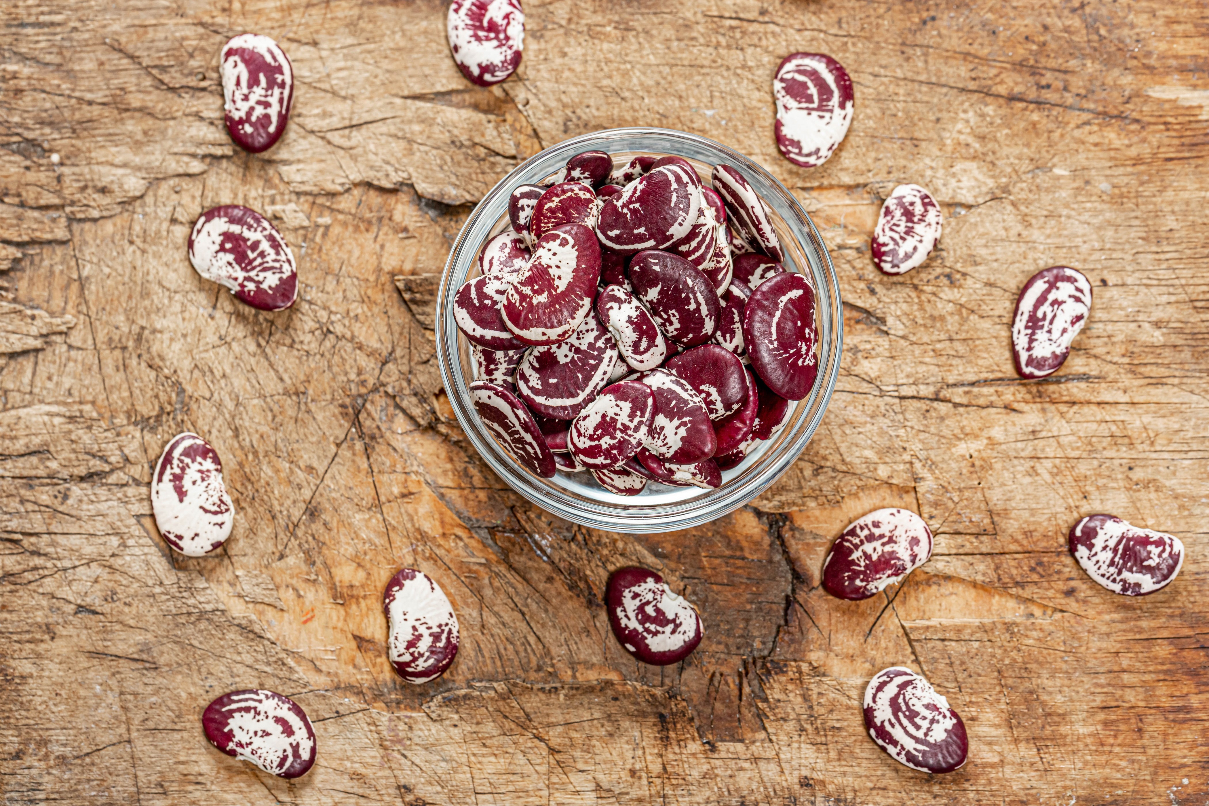 Borlotti beans in a bowl on wood HD Wallpaper