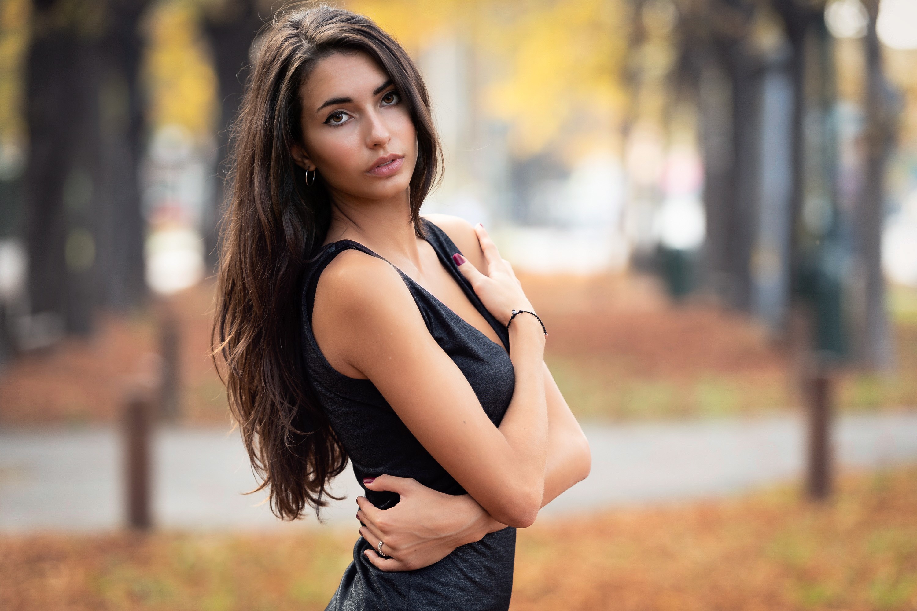 Beautiful woman with long dark hair posing outdoors HD Wallpaper