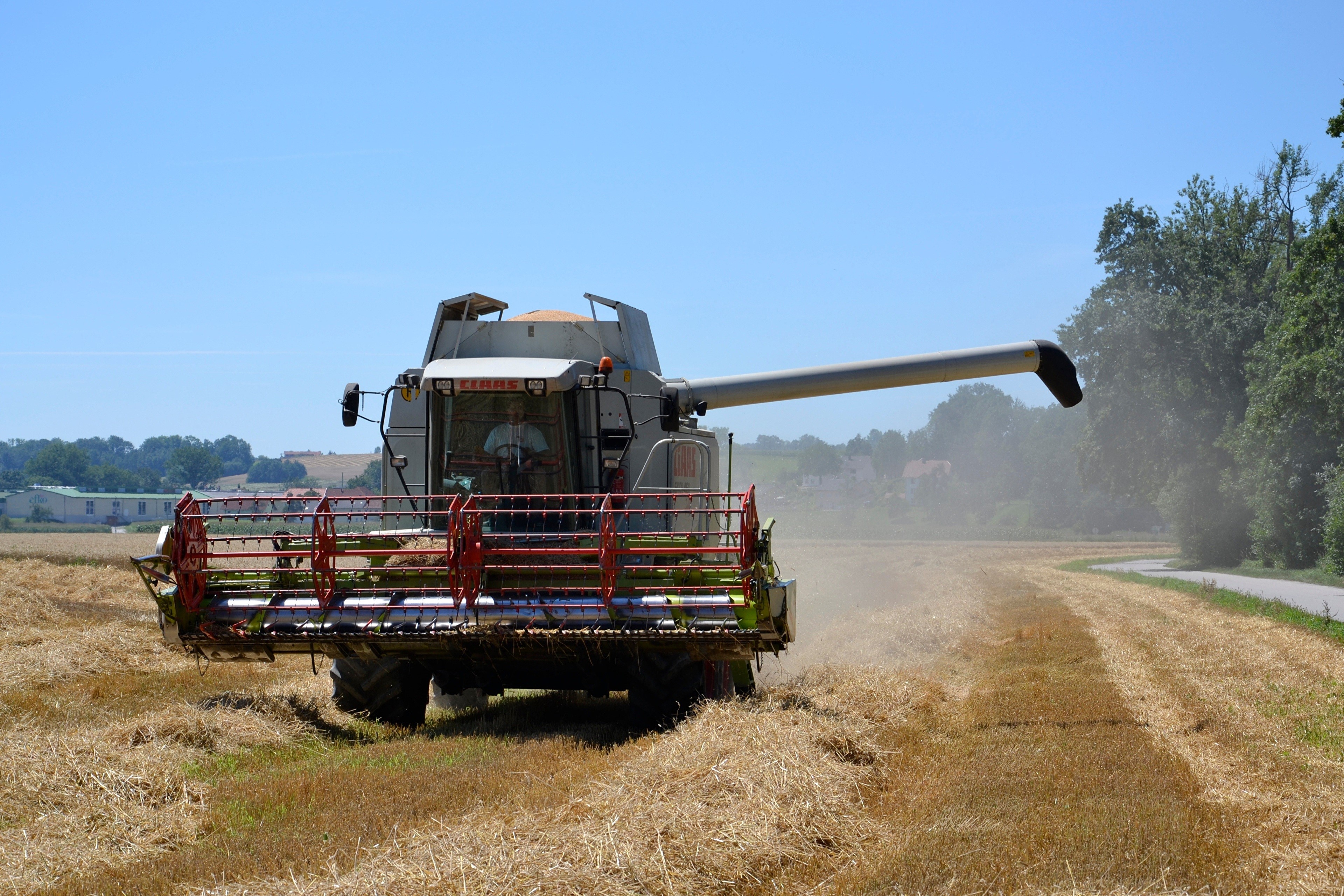 Combine harvester working in a field HD Wallpaper