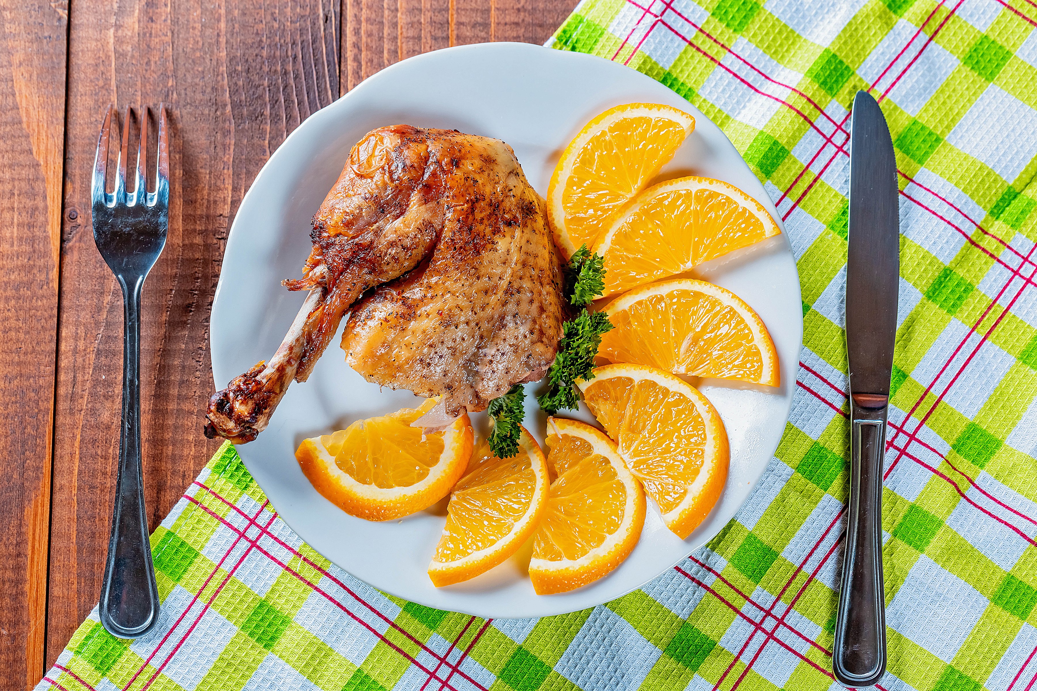 Roast chicken leg with orange slices on a plate HD Wallpaper