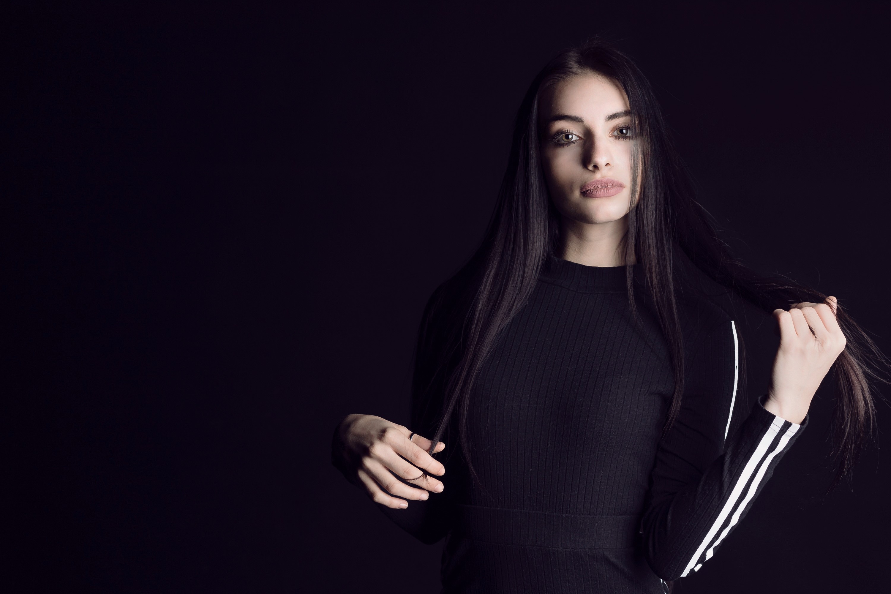 Brunette girl with long hair posing against black background HD Wallpaper