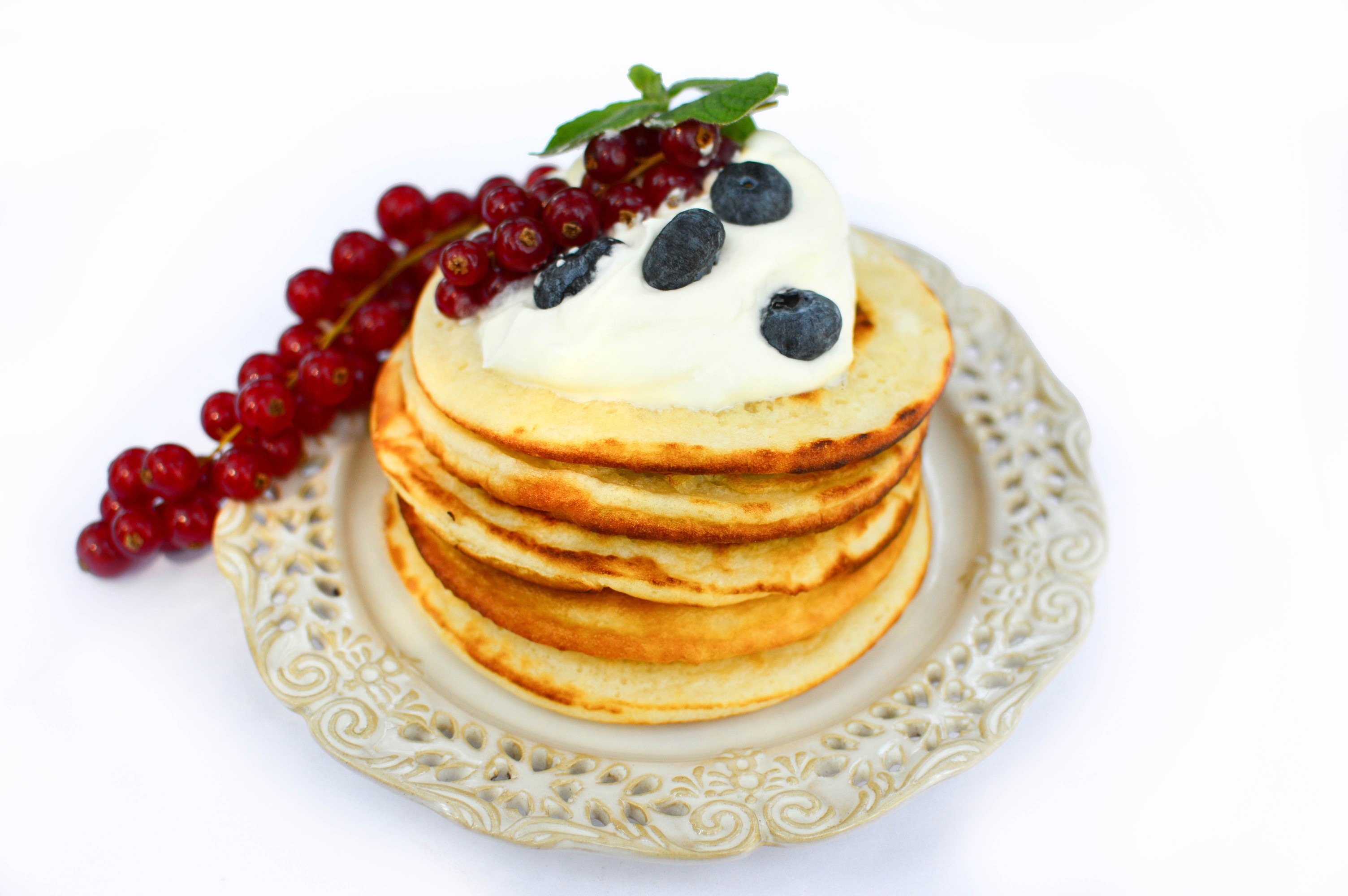 Pancakes with whipped cream, blueberries, and red currants on a plate HD Wallpaper