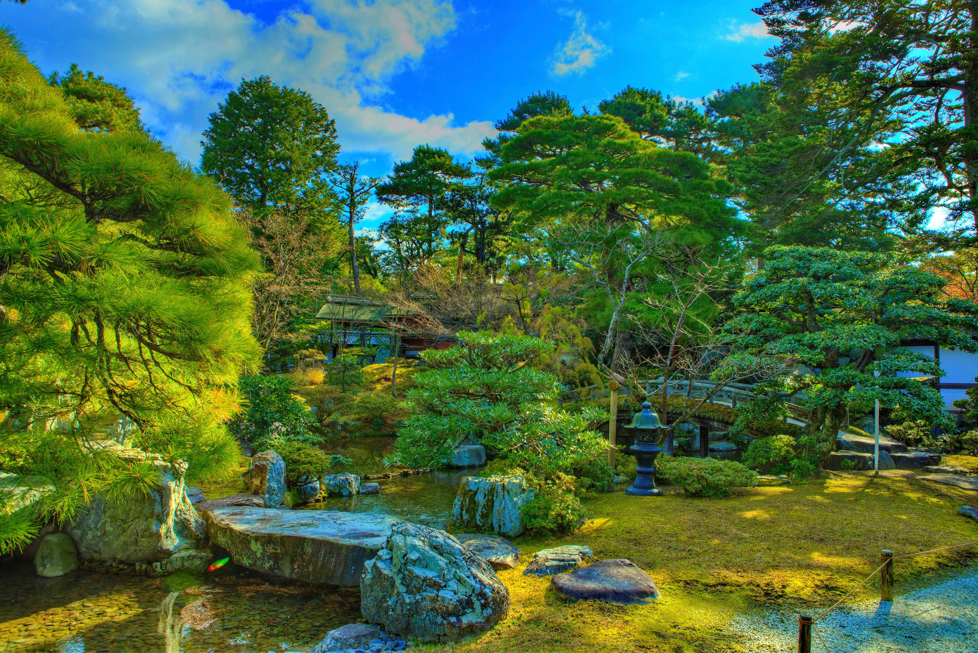 Japanese garden with pond, trees, and traditional building HD Wallpaper