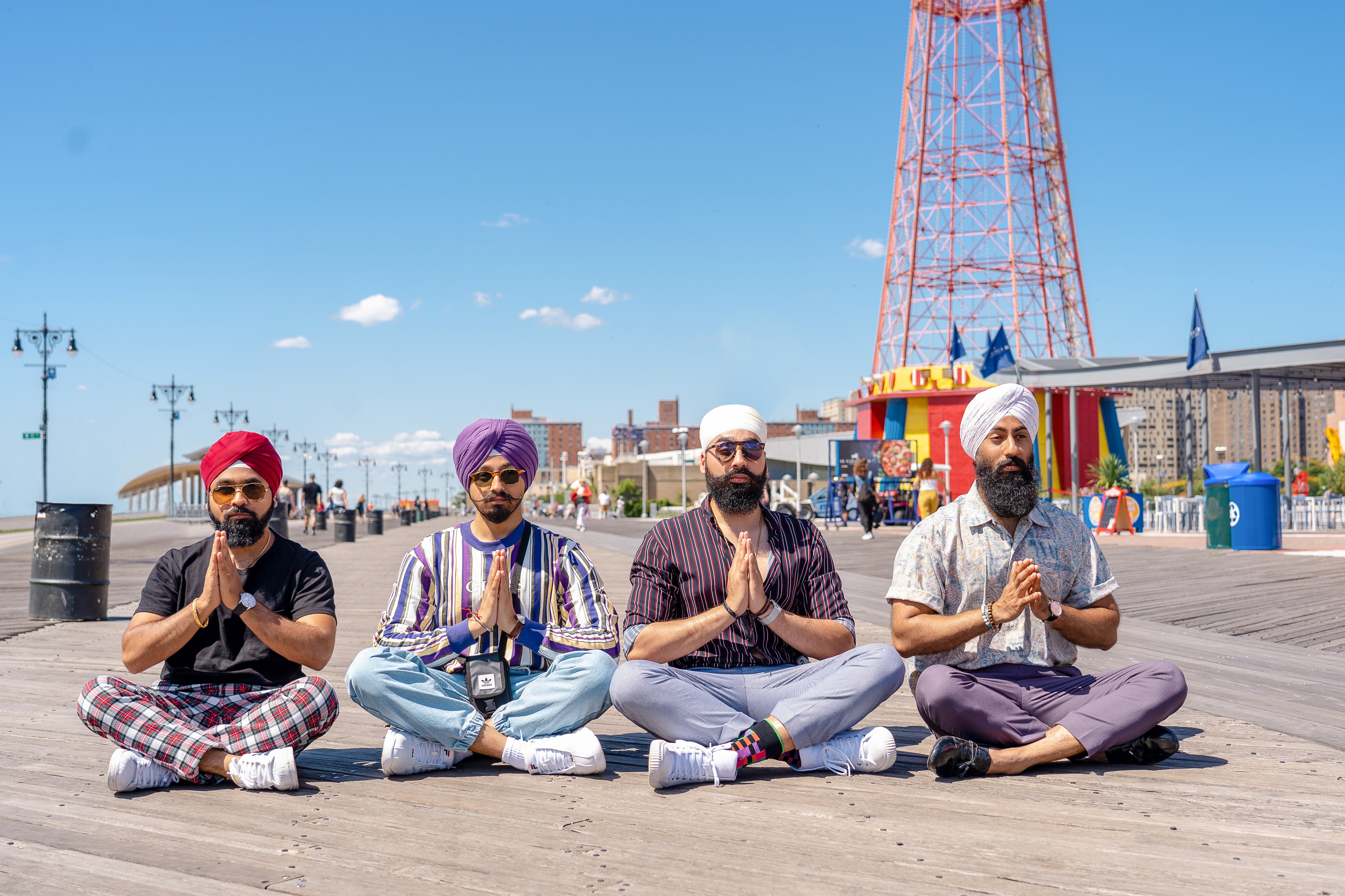 Four men meditating on a boardwalk HD Wallpaper