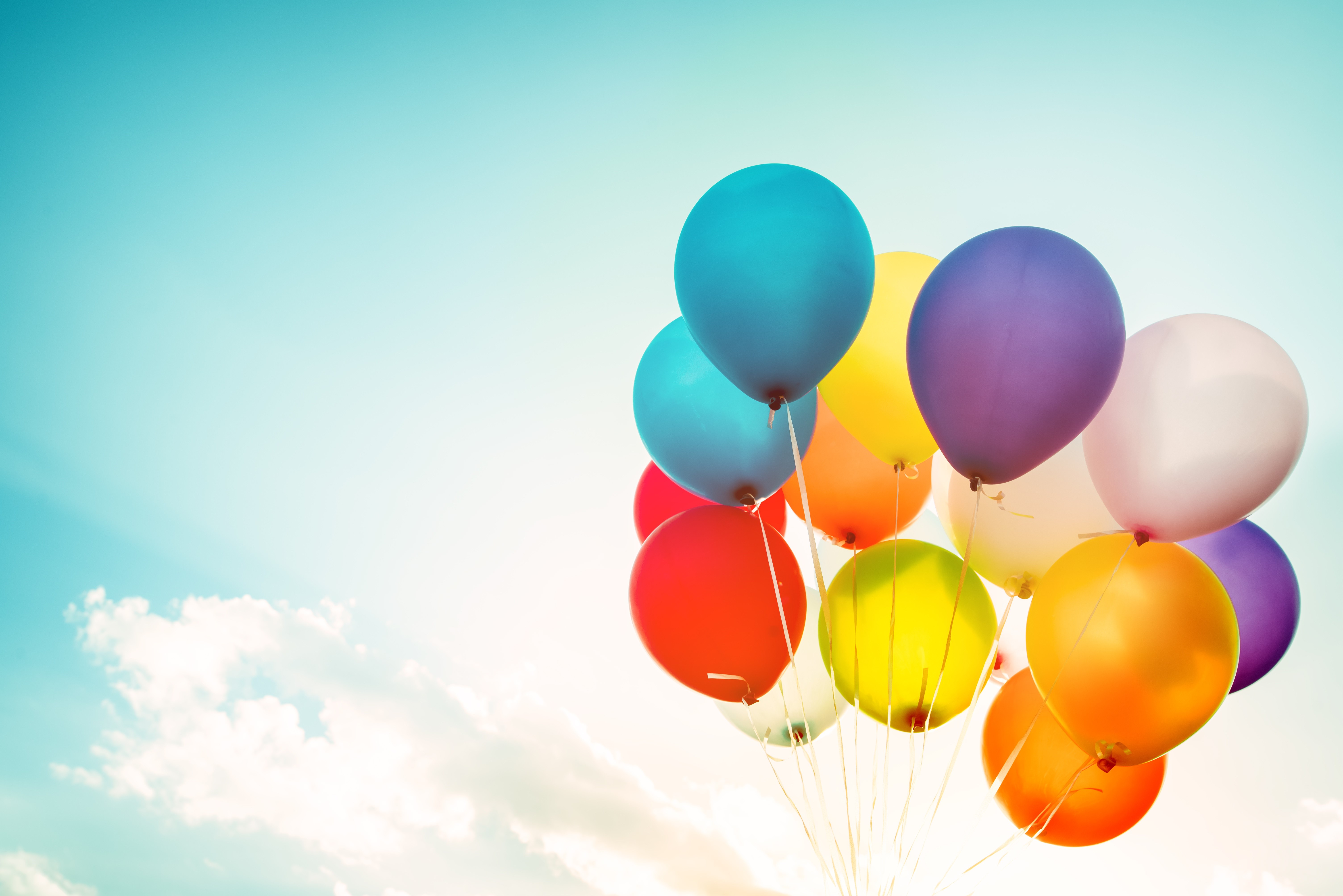 A bunch of colorful balloons against a bright sky HD Wallpaper