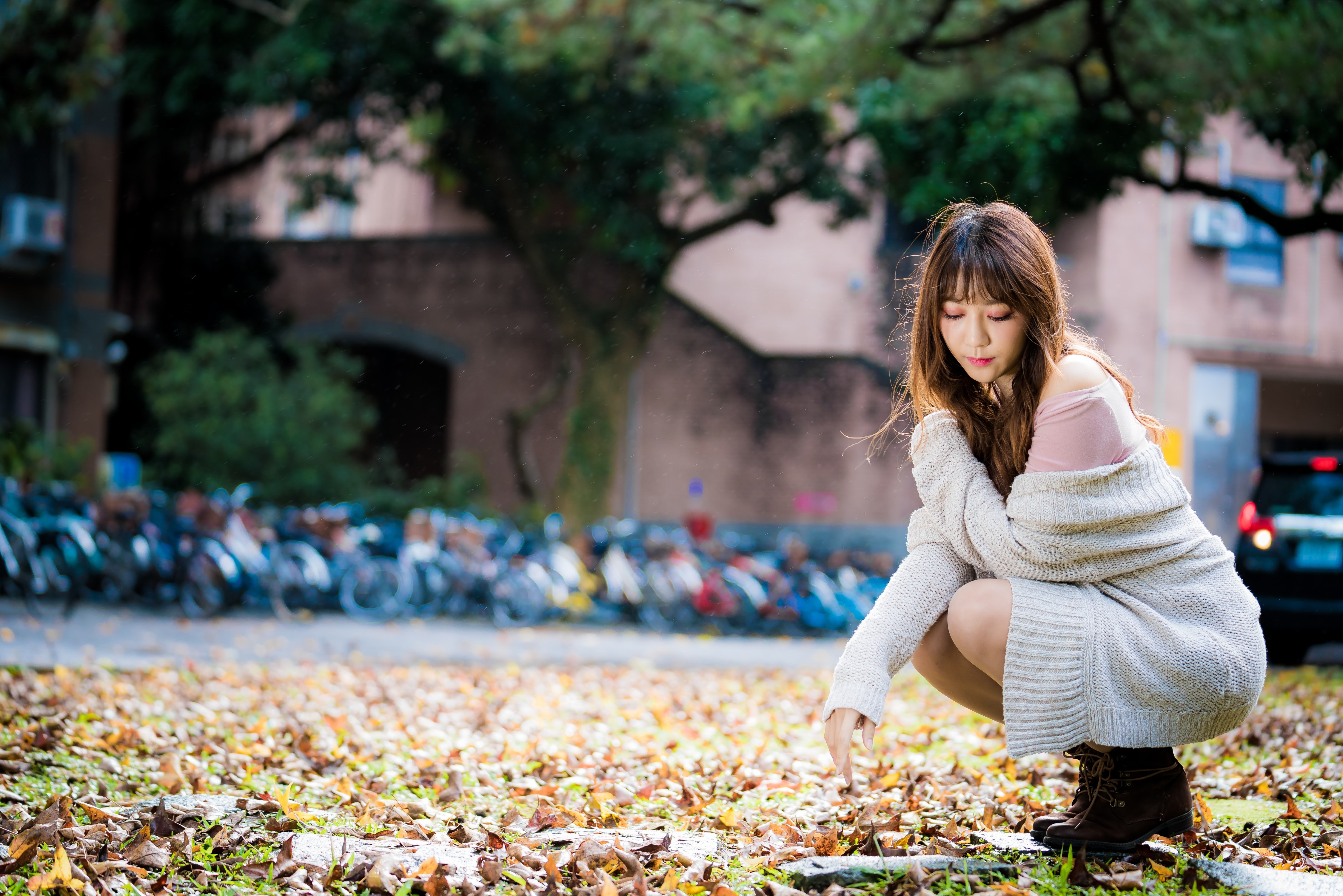 4K Portrait of a Woman Sitting Amid Autumn Leaves HD Wallpaper