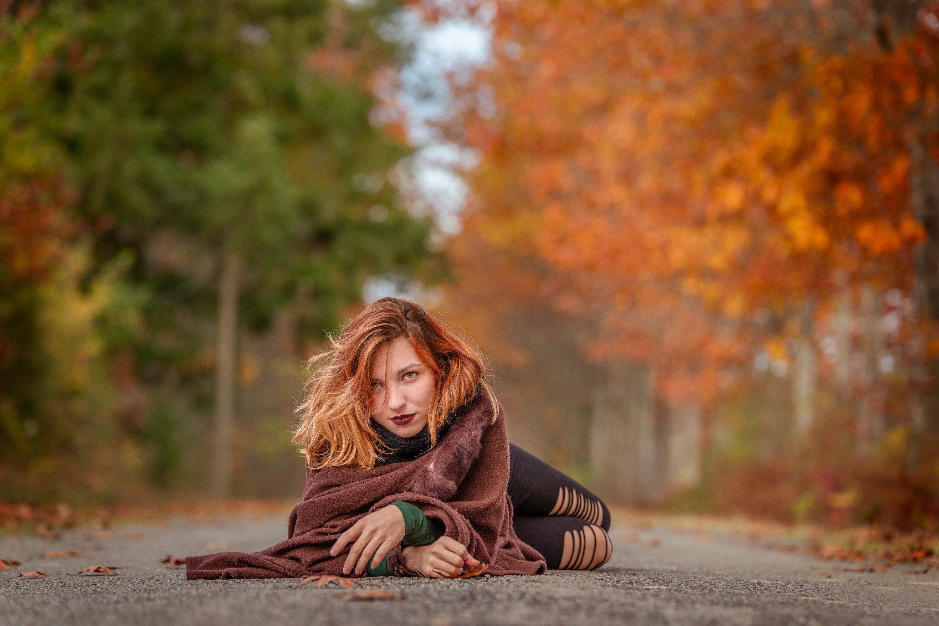 Redhead girl lying on a road in autumn HD Wallpaper