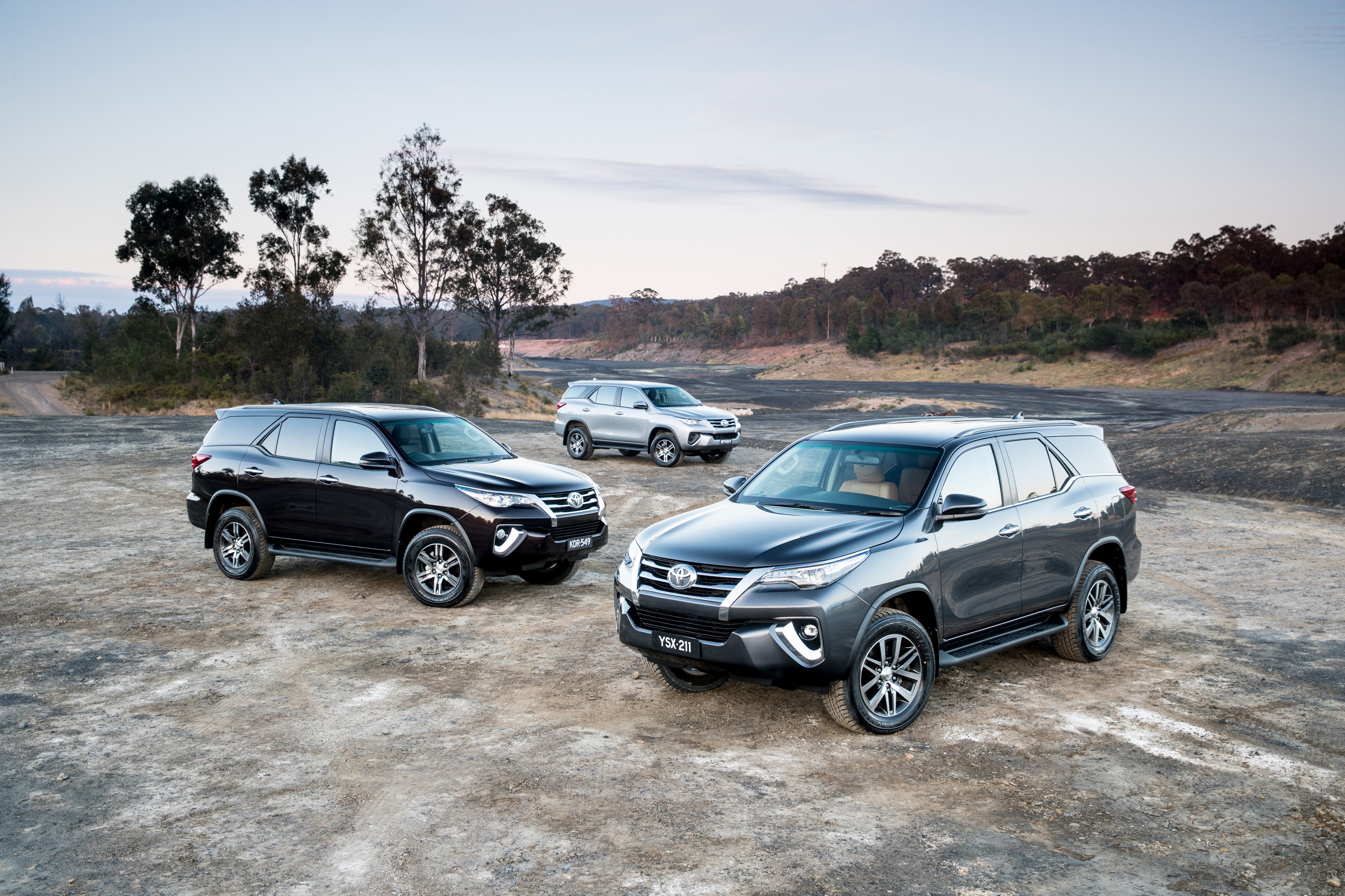 Three Toyota Fortuner SUVs in a landscape HD Wallpaper