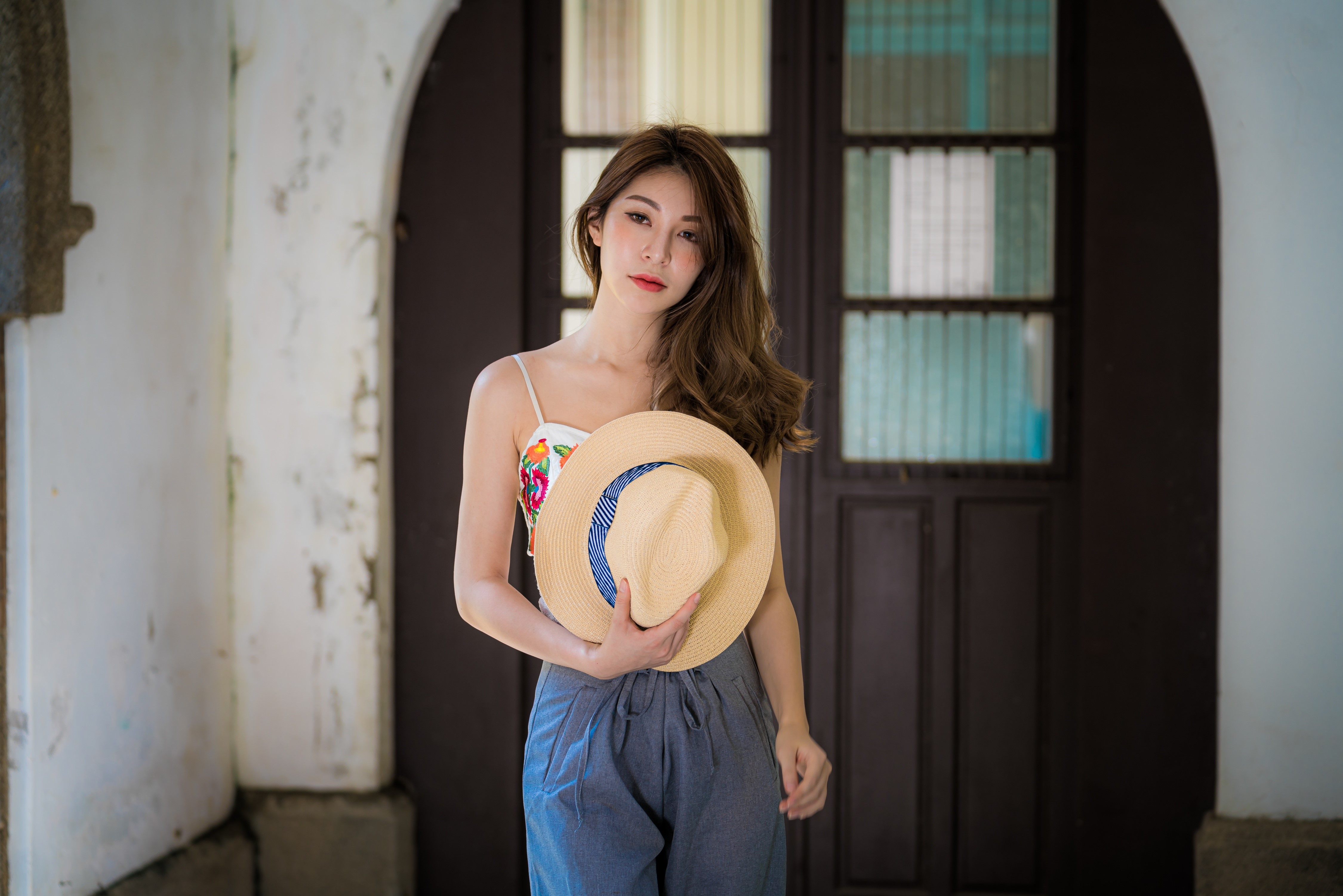 Asian woman with brown hair holding a hat HD Wallpaper