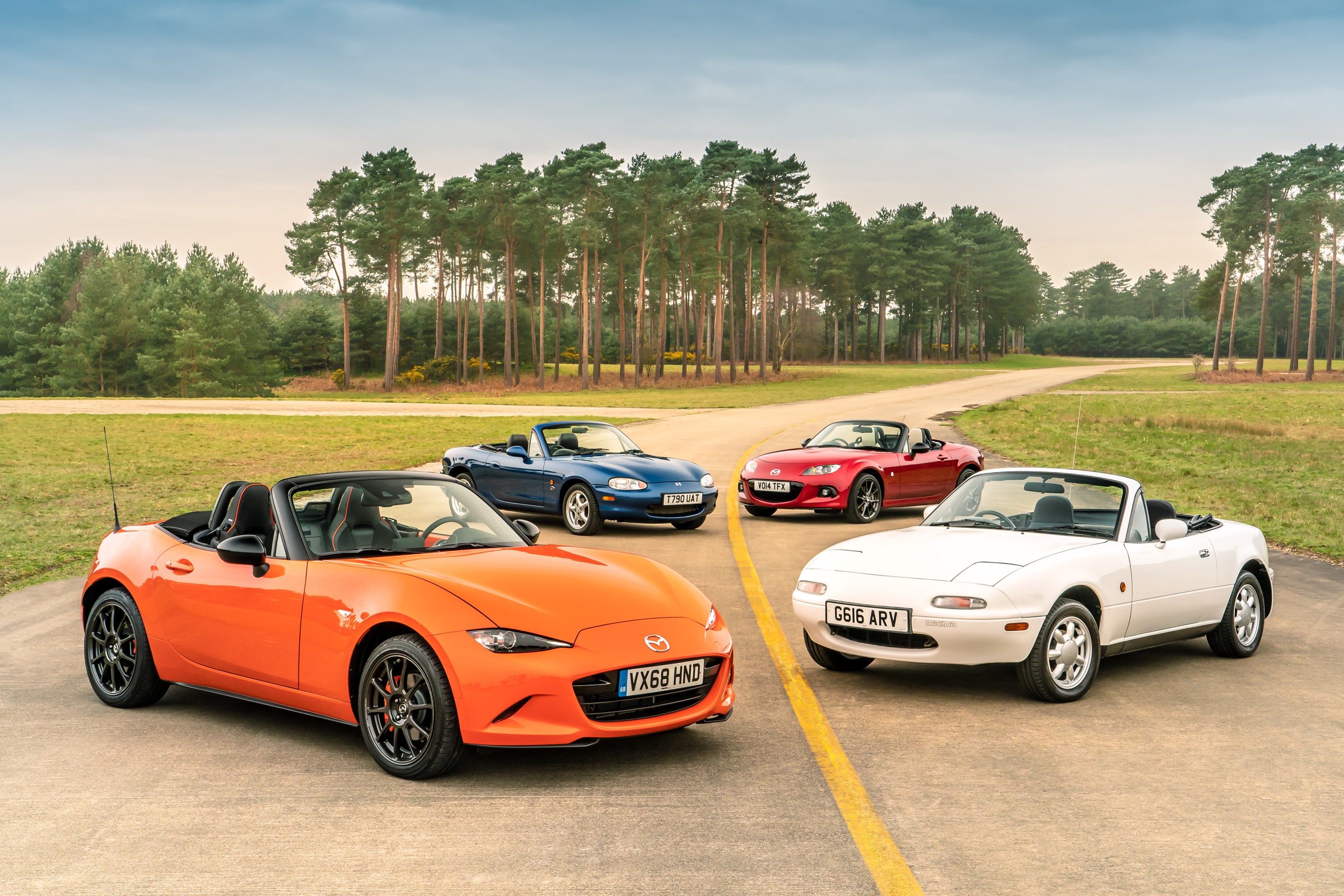 Four Mazda MX-5 convertibles on a road HD Wallpaper