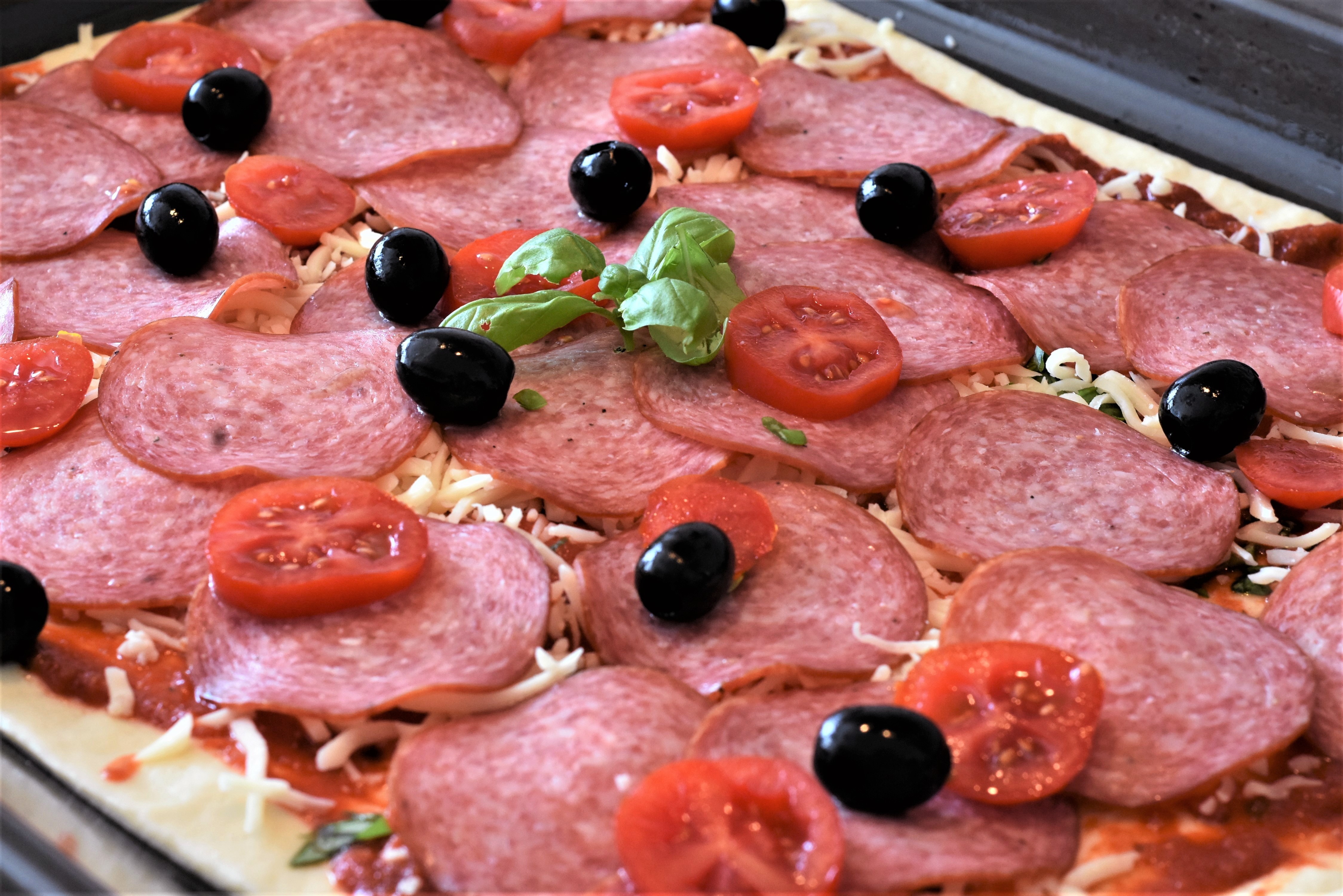 4K Closeup of Pizza with Sausage, Olives, and Tomatoes HD Wallpaper