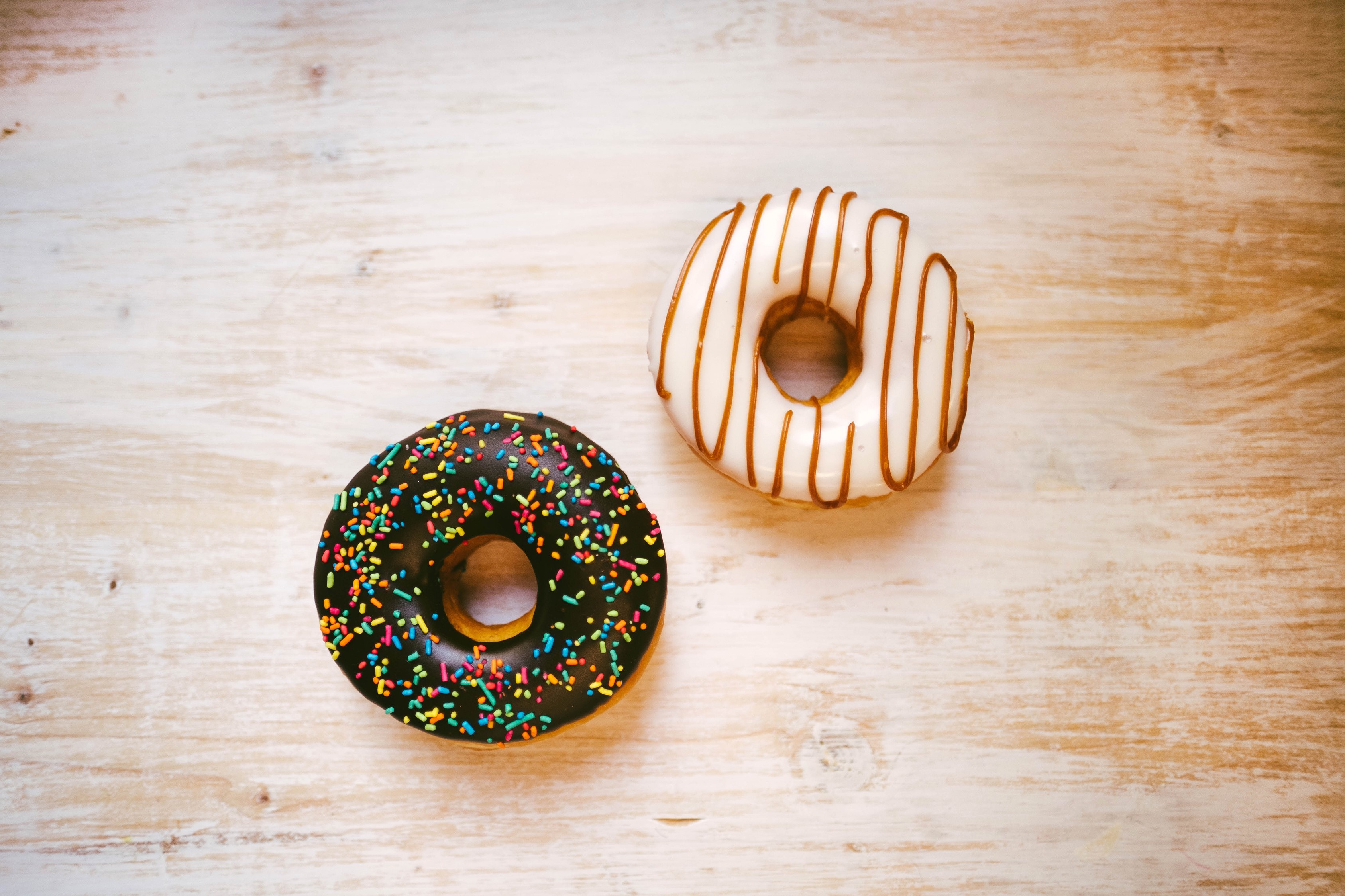 Two donuts on a wooden surface HD Wallpaper