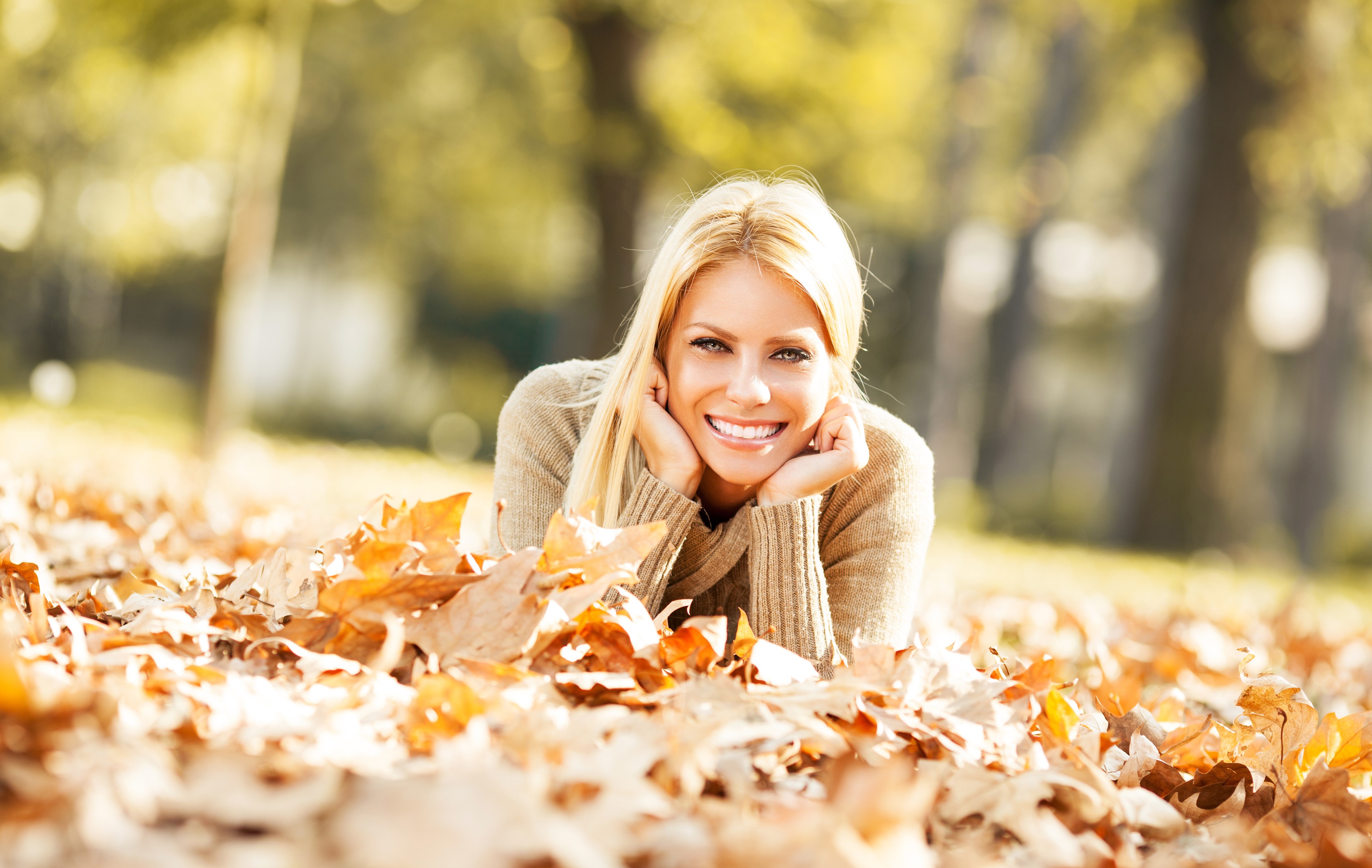 Blonde girl lying in autumn foliage HD Wallpaper