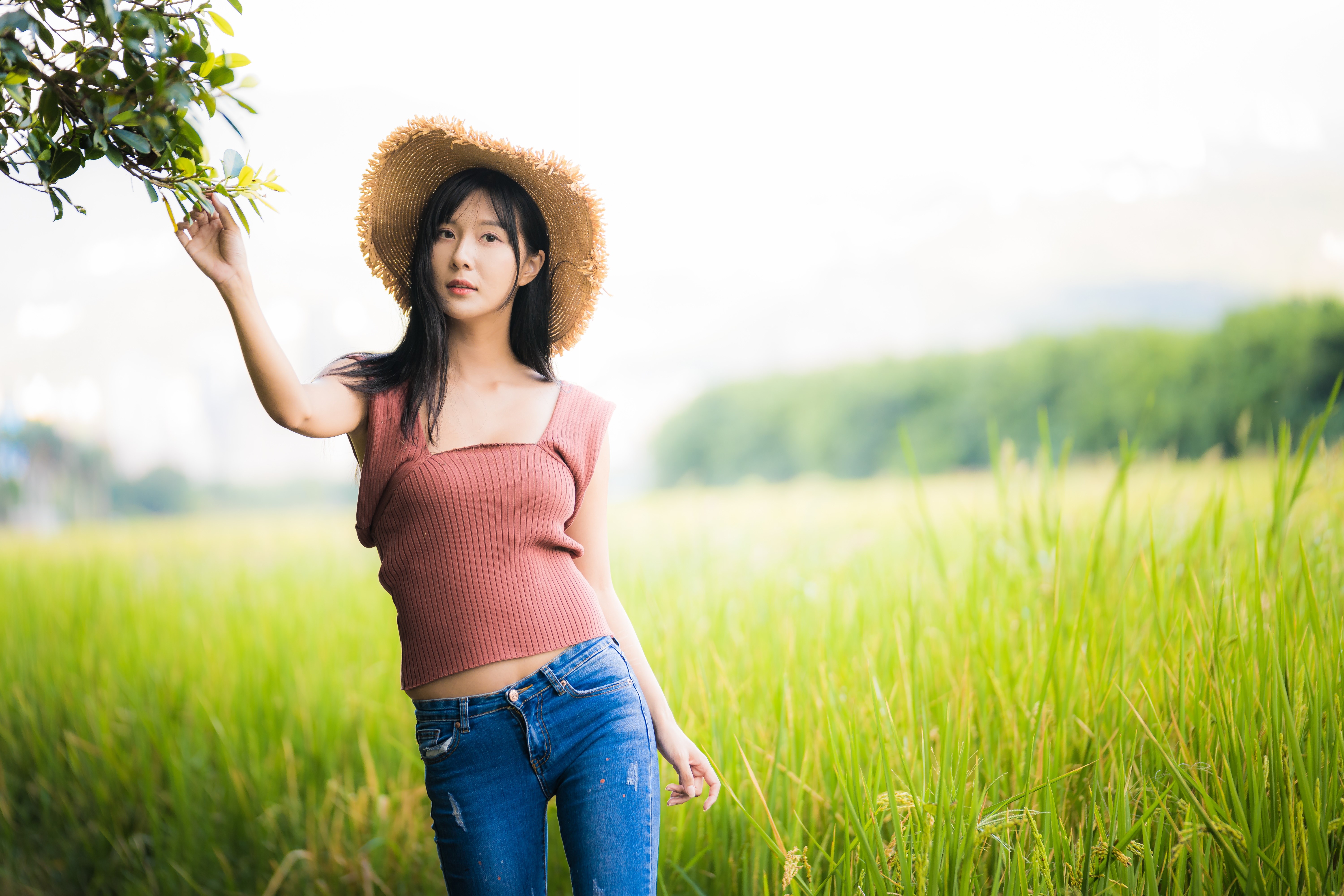 Brunette Girl in Hat and Jeans in Green Field 4K HD Wallpaper