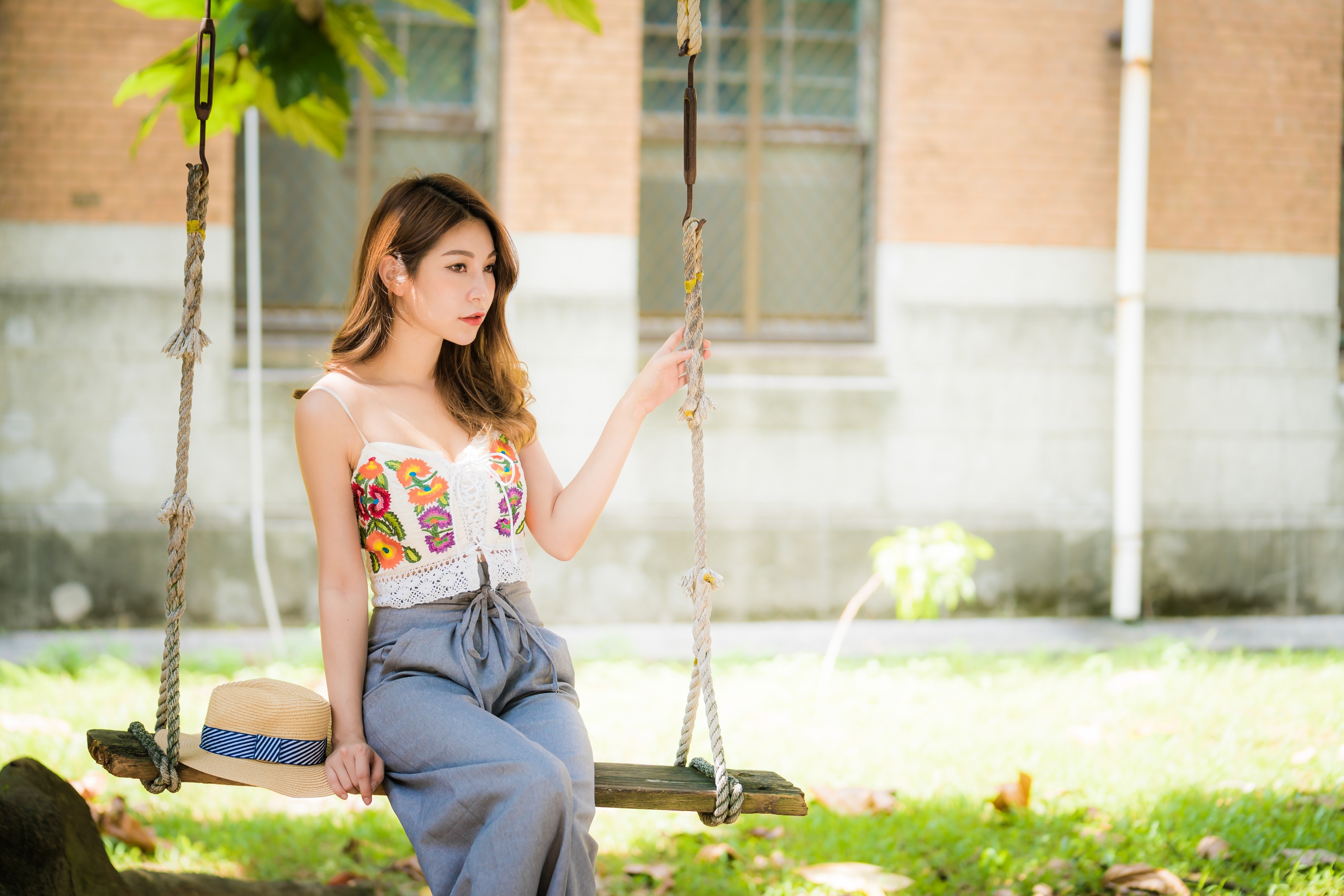 4K Asian Woman Sitting on Swing with Hat HD Wallpaper
