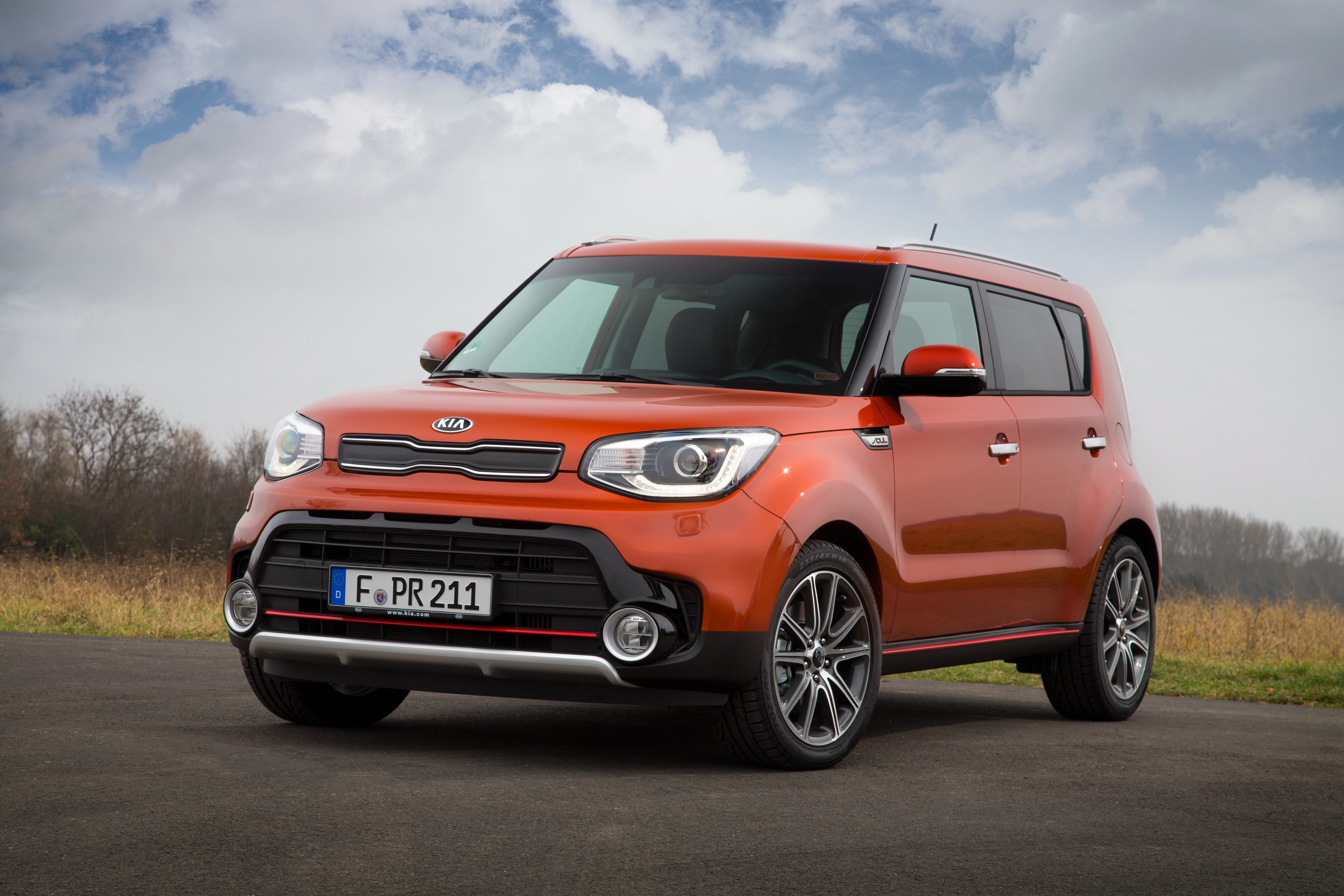 Orange Kia Soul car on a road HD Wallpaper